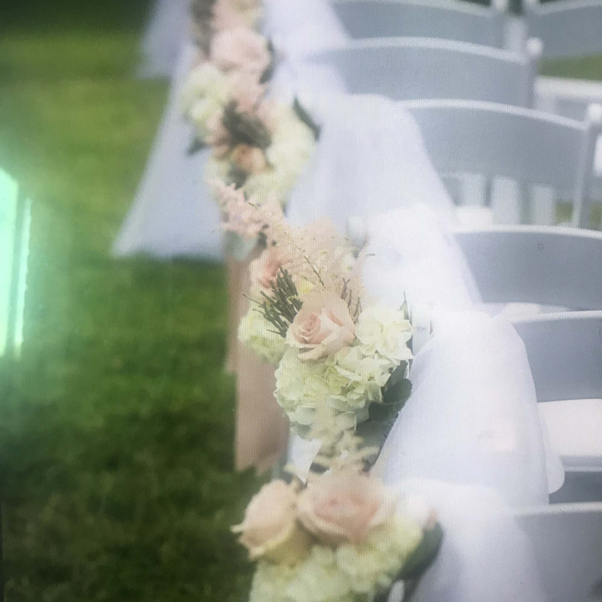 White chairs decorated with pale floral garlands and sheer draping