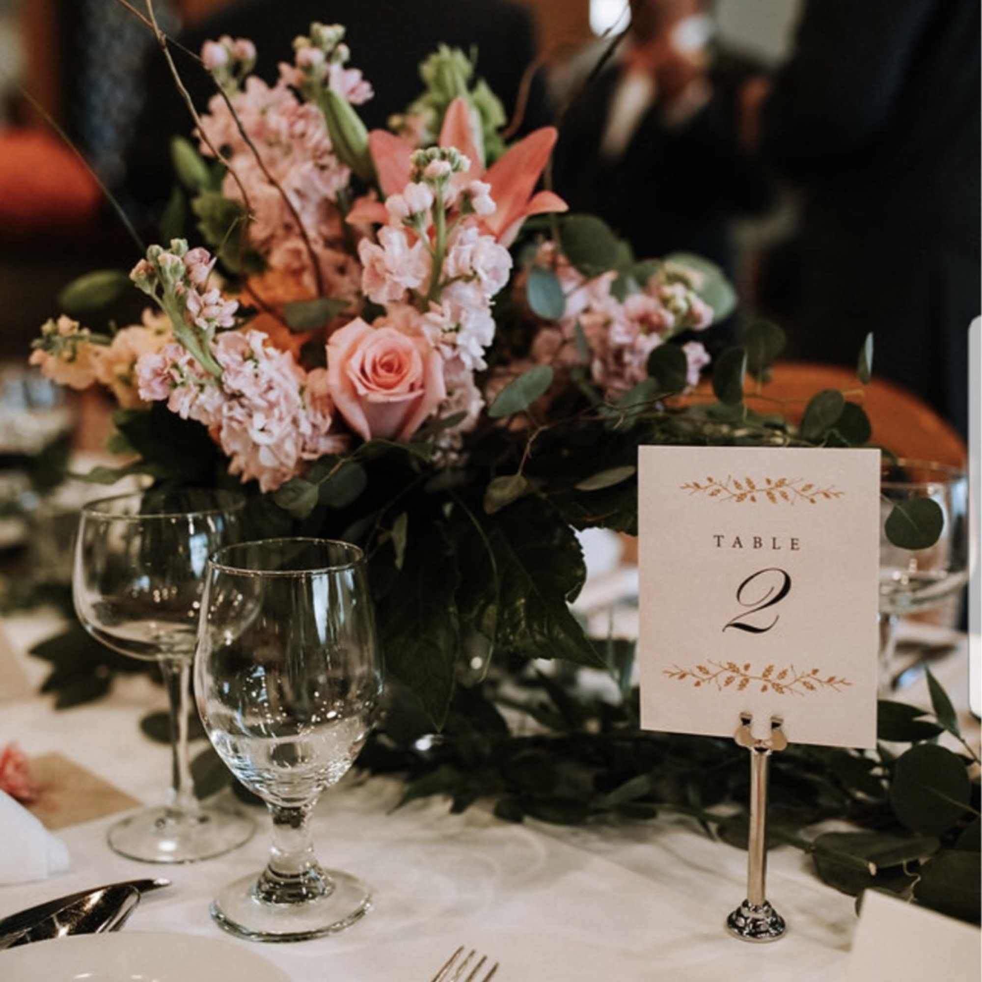 Pink floral table centerpiece with a table number card