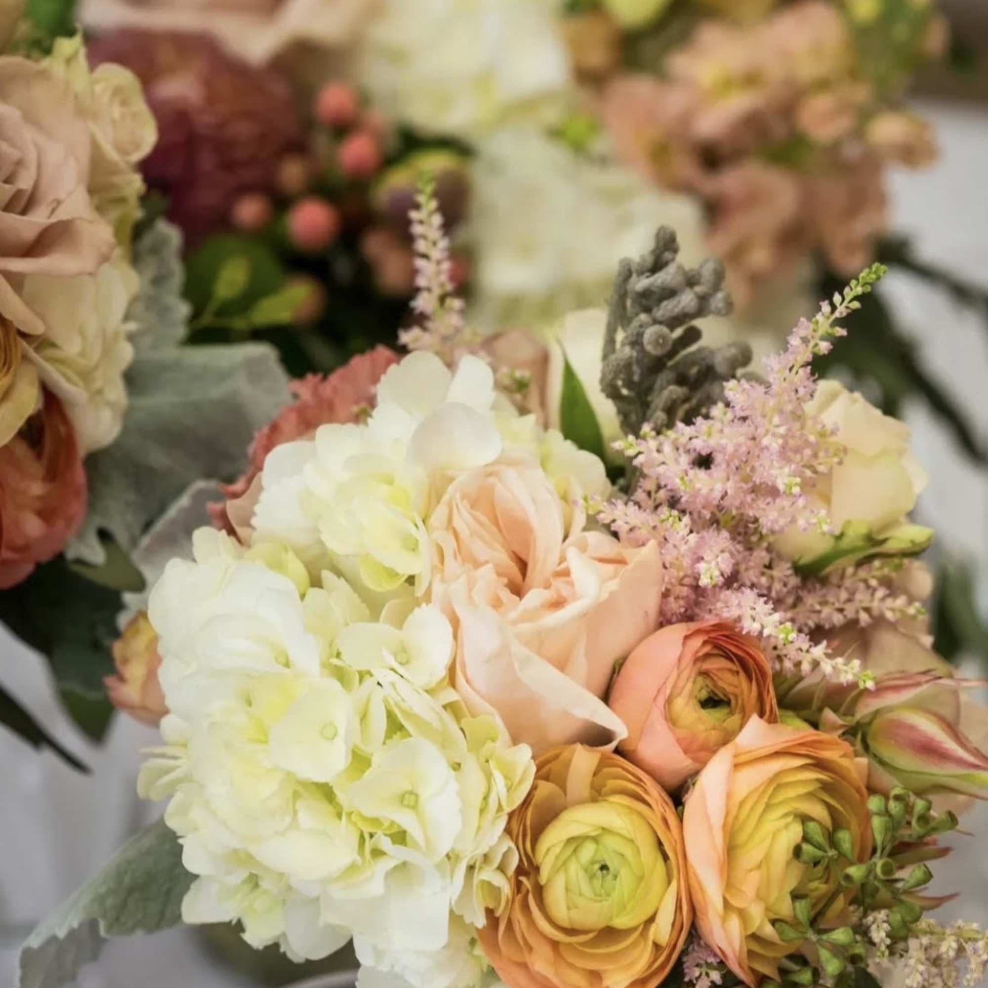 Bouquet of peach roses, white hydrangeas, and pink filler flowers