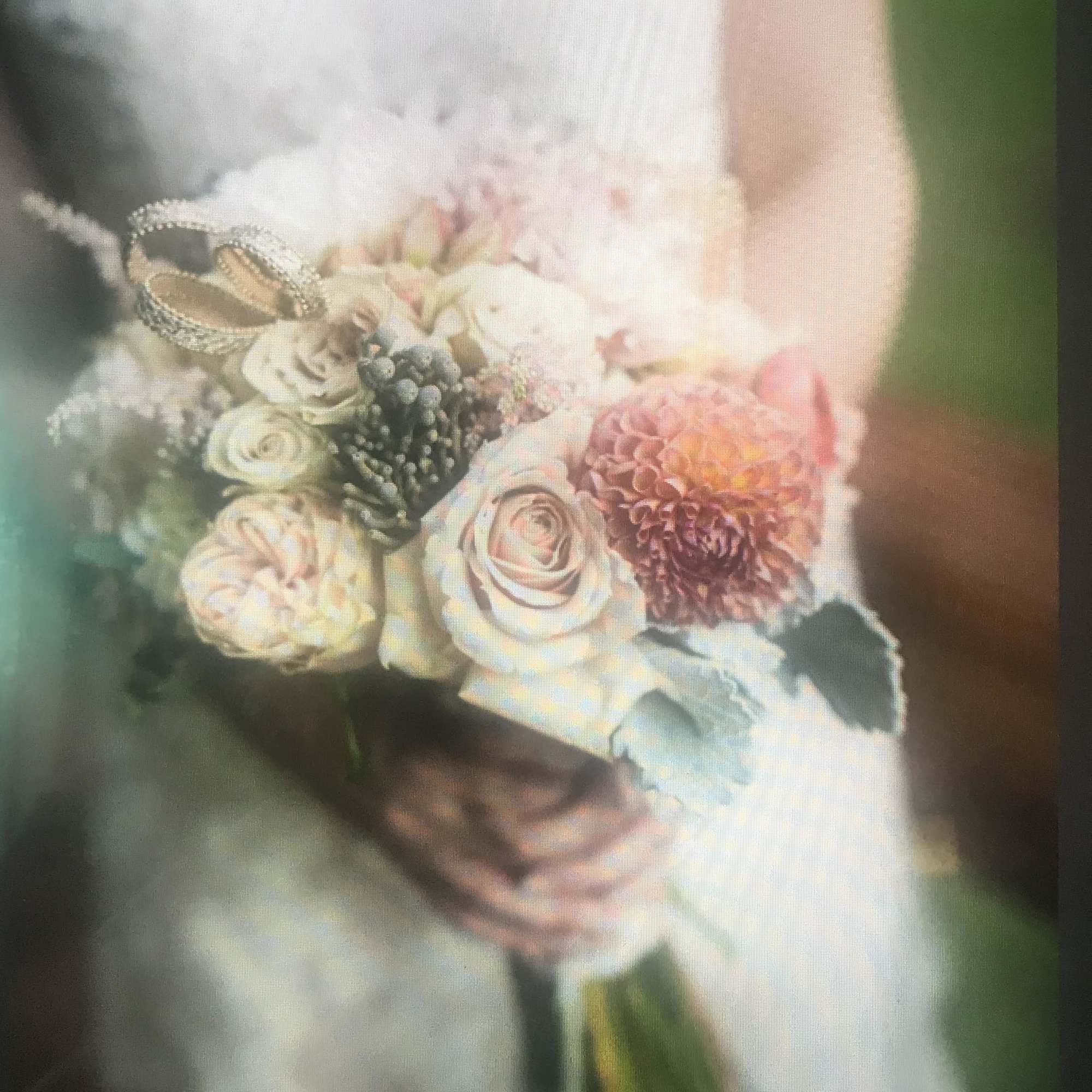 Bridal bouquet of pale roses and a pink dahlia with jeweled butterfly accents