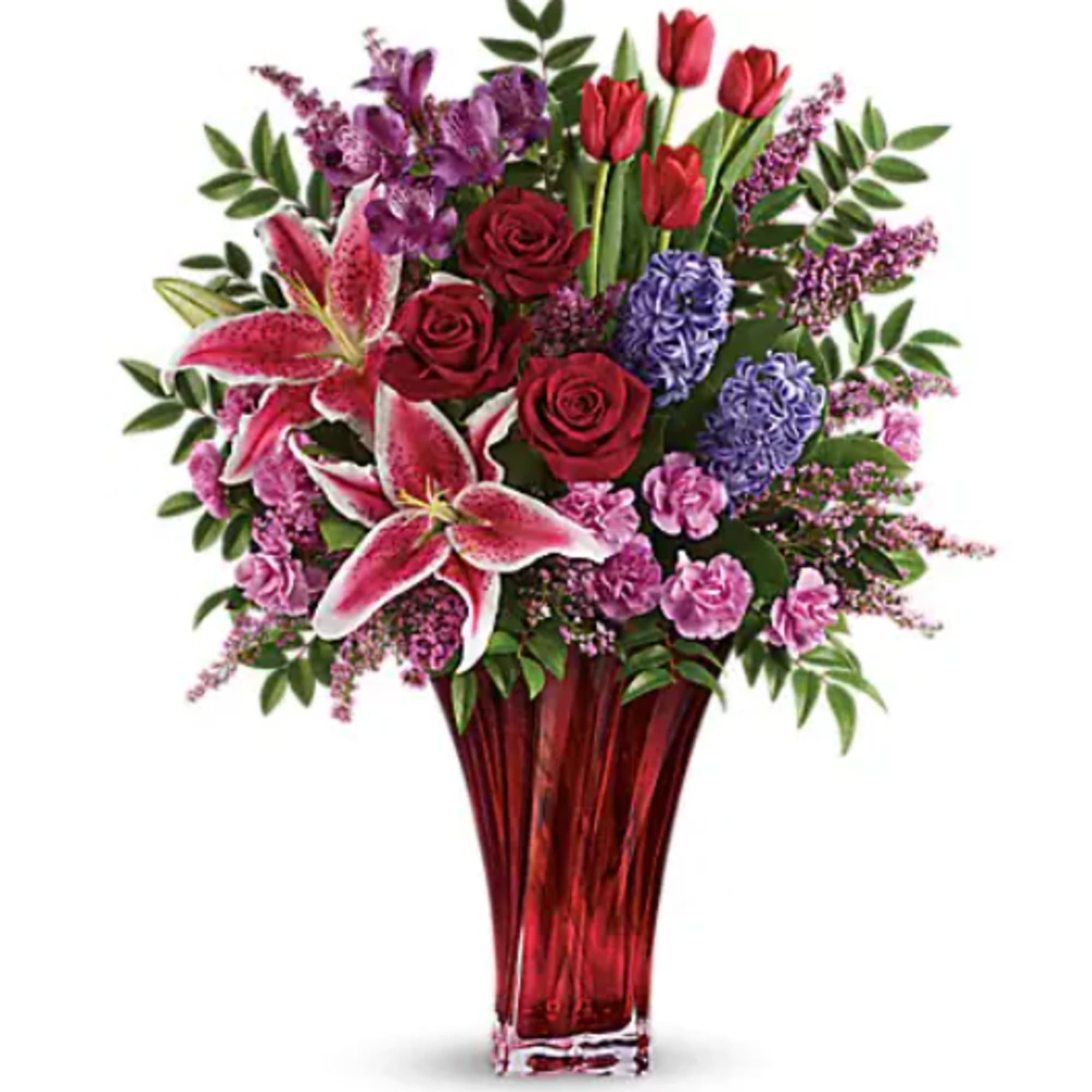 Mixed bouquet of red, pink, and purple flowers in a red glass vase