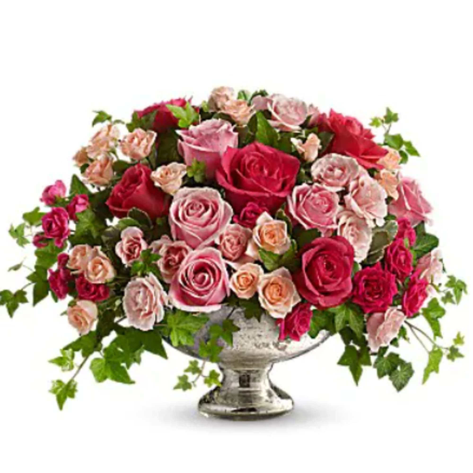 Pink and red roses arranged in a silver pedestal vase