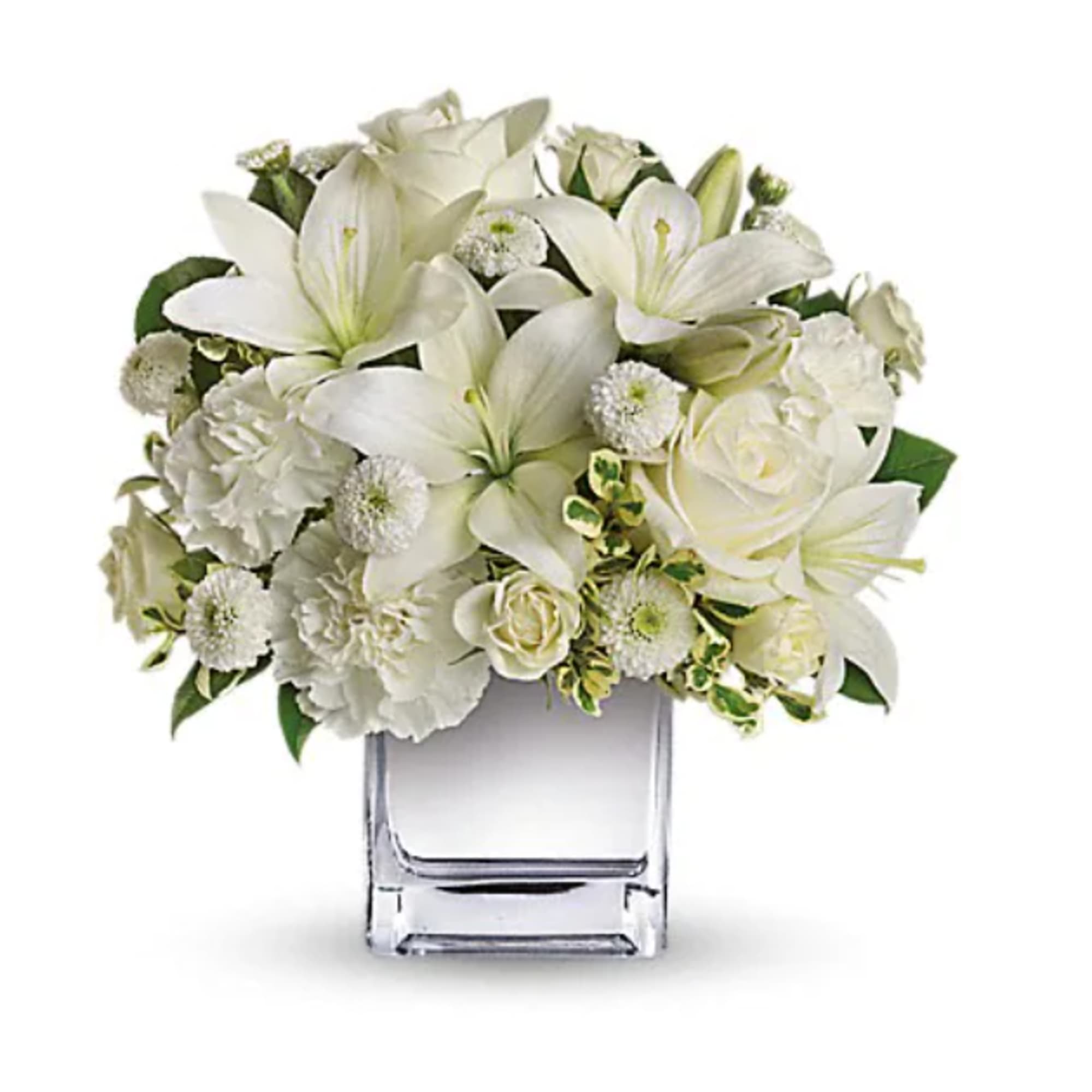 White lilies and roses arranged in a clear square vase