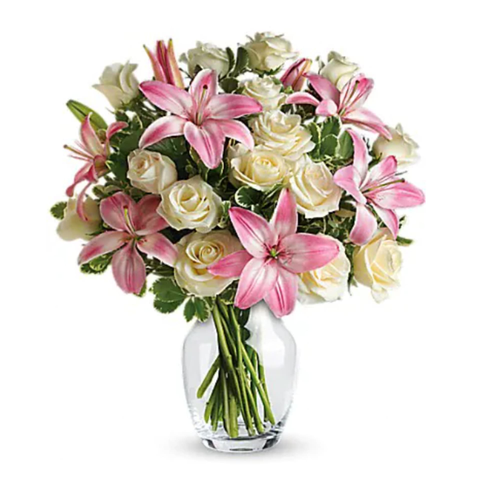 Pink lilies and white roses arranged in a clear glass vase