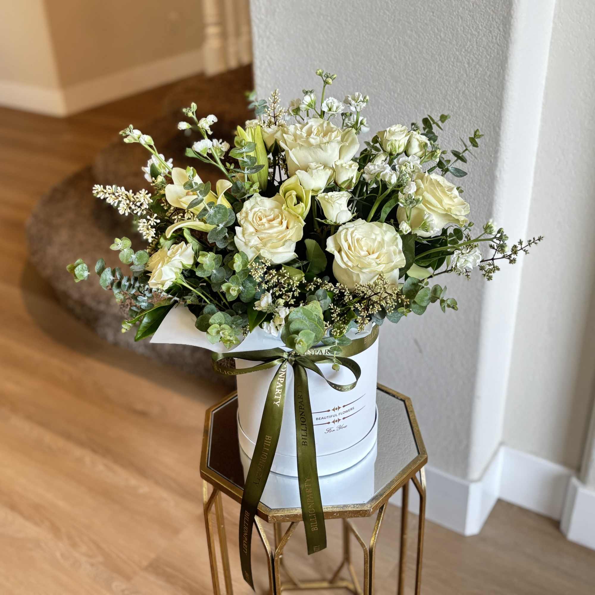 Cream and white rose bouquet in a white hatbox with a ribbon