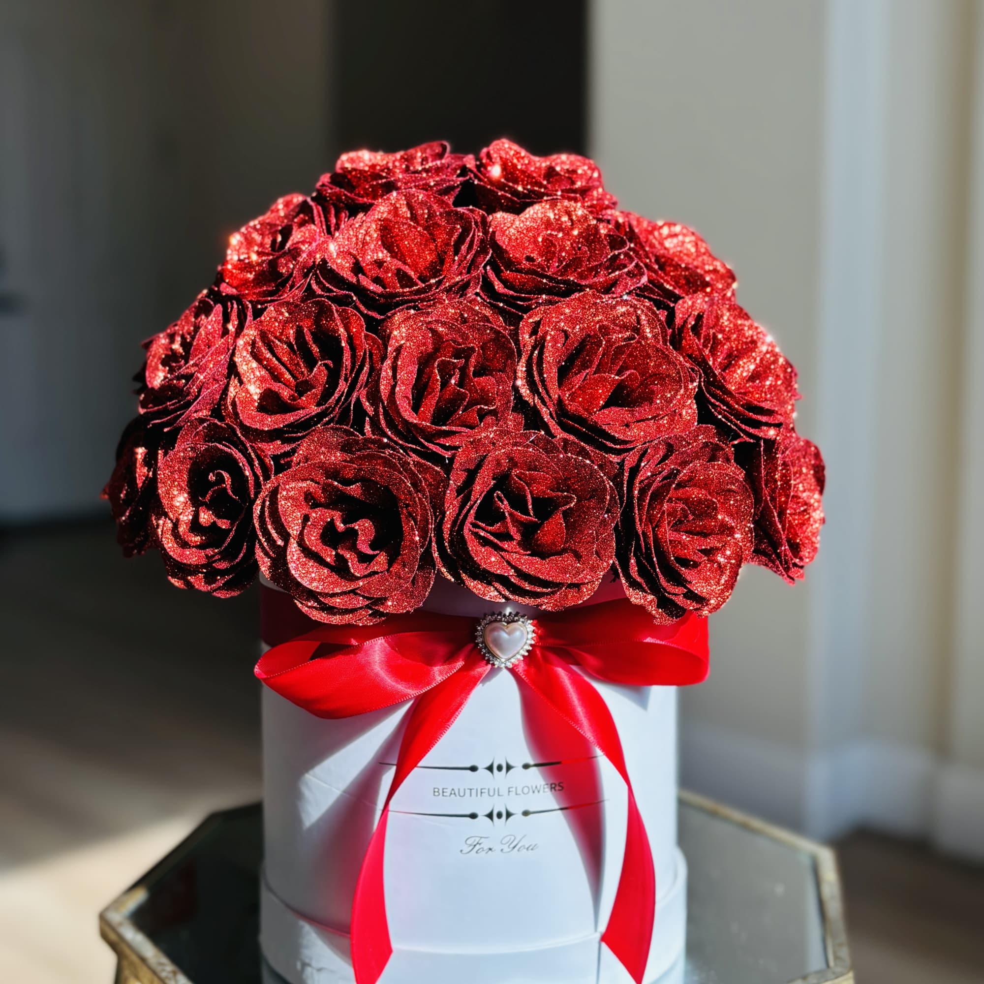 Red glitter roses in a white hat box with a red ribbon