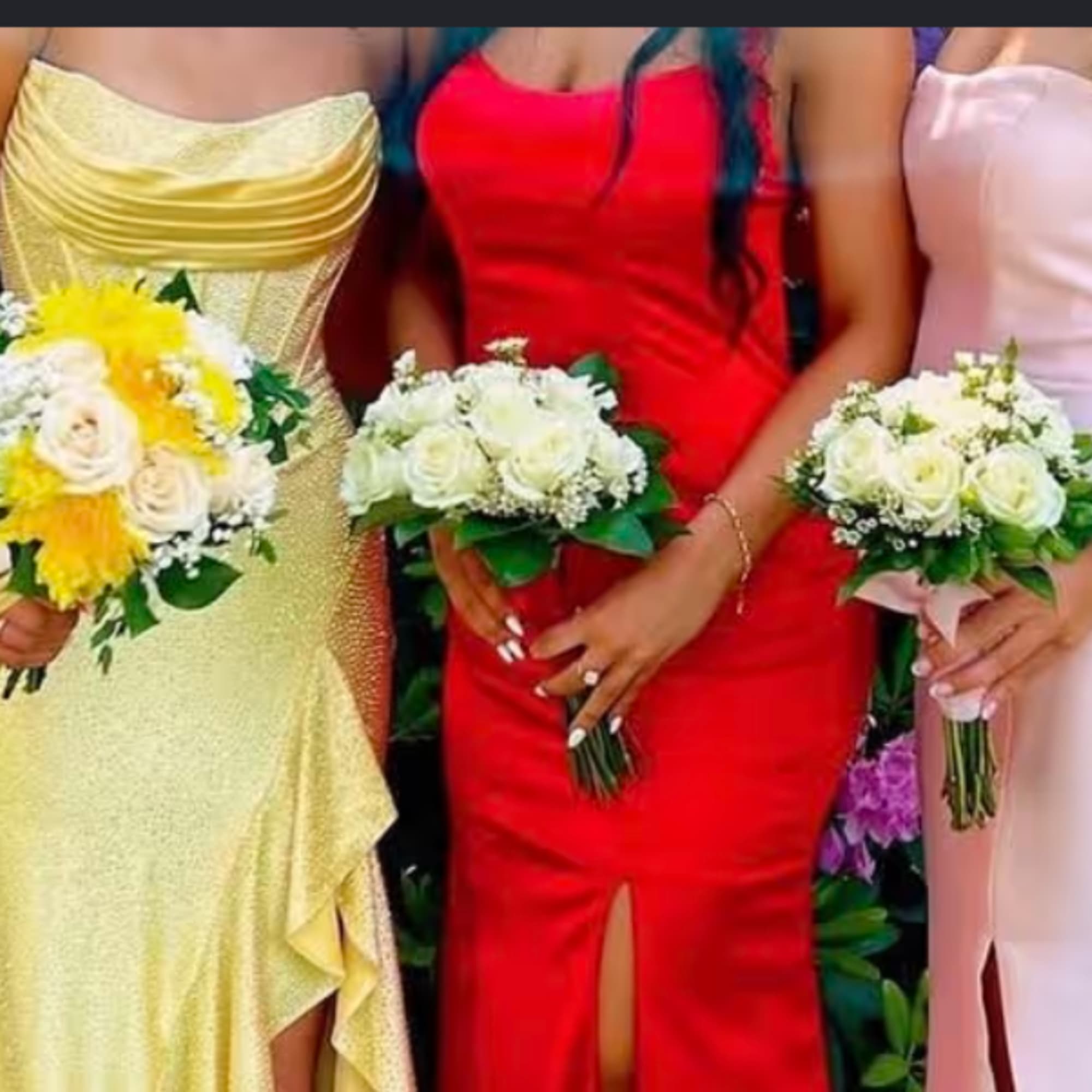 Three women hold small bouquets of white and yellow flowers