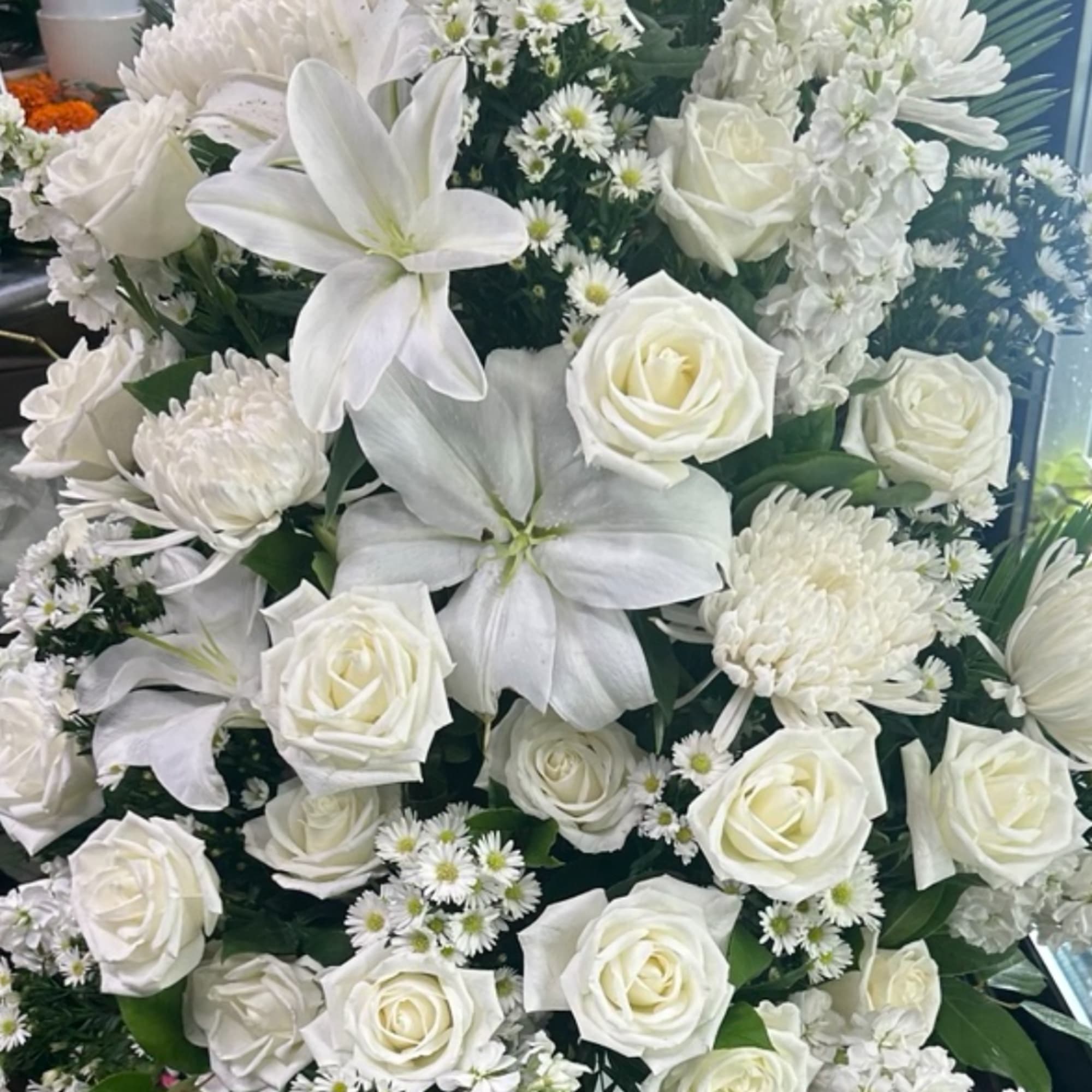 White roses and lilies arranged with small white daisies