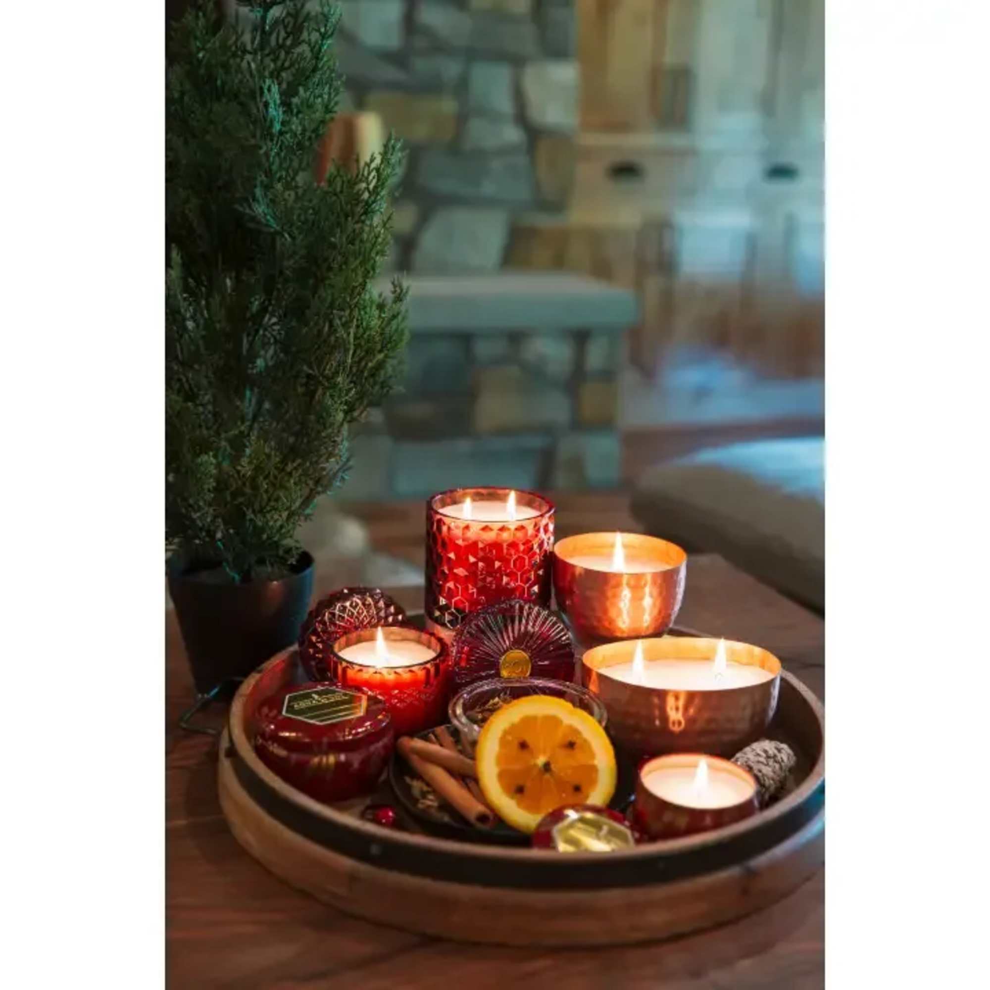 Tray of lit candles with a small potted evergreen and dried citrus slices
