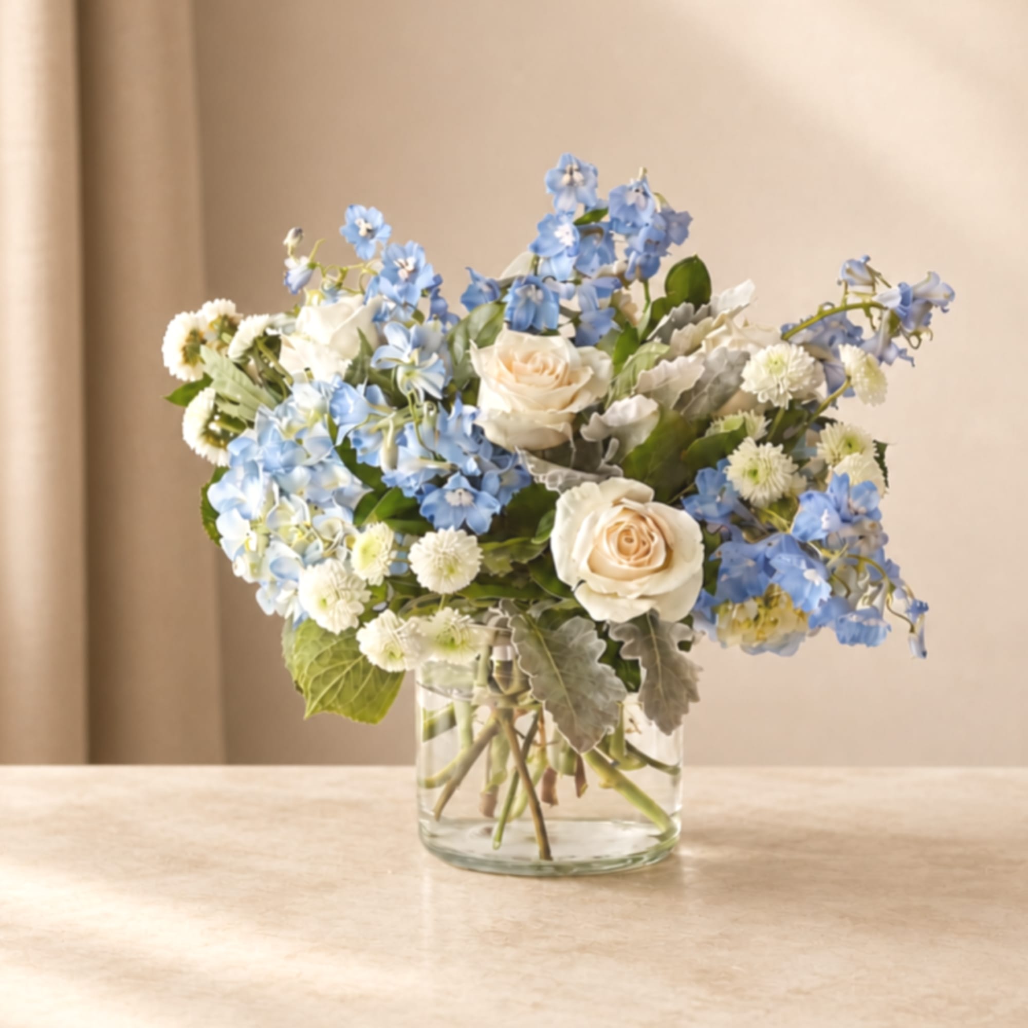 Blue and white flowers arranged in a clear glass vase