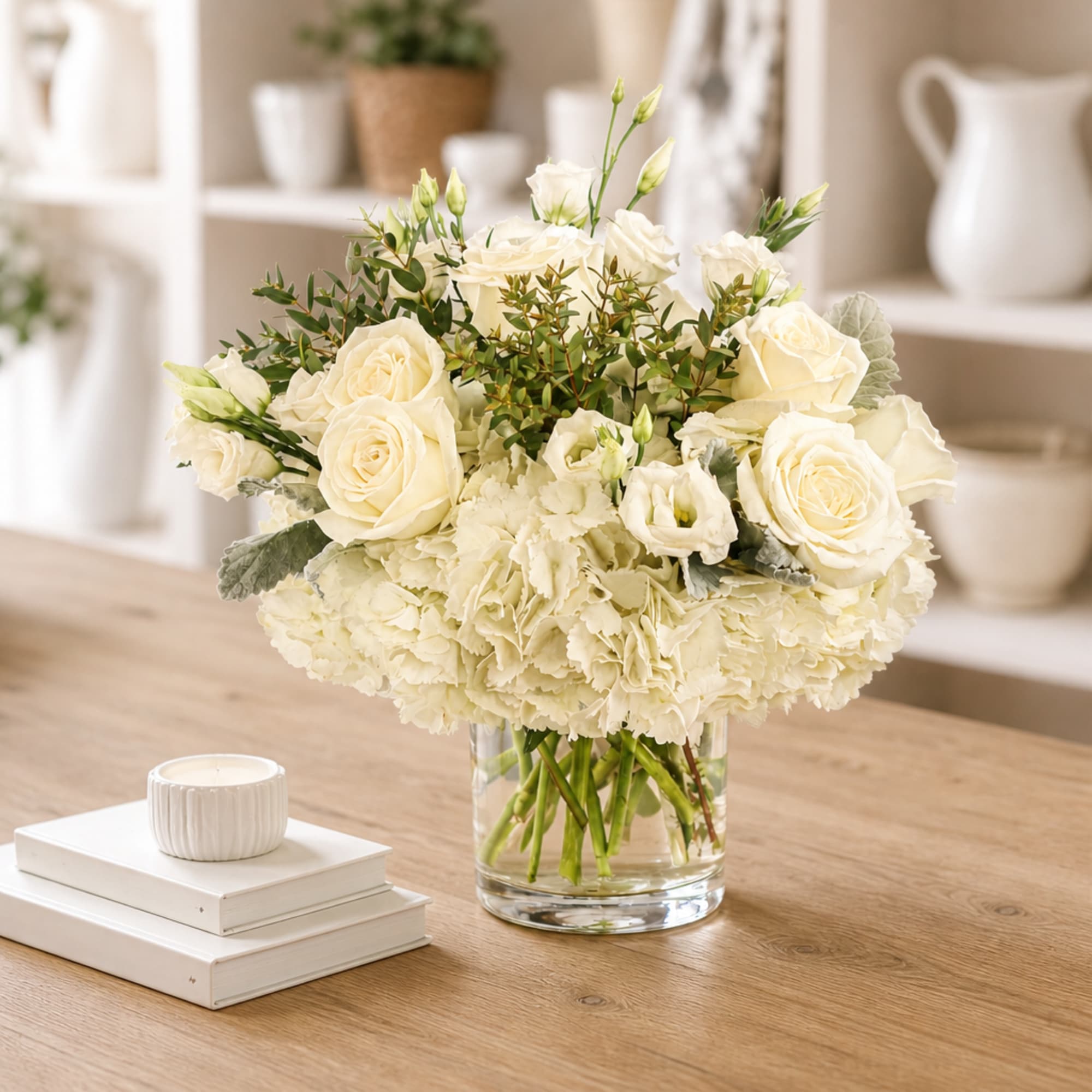 Cream rose and hydrangea arrangement in a clear glass vase