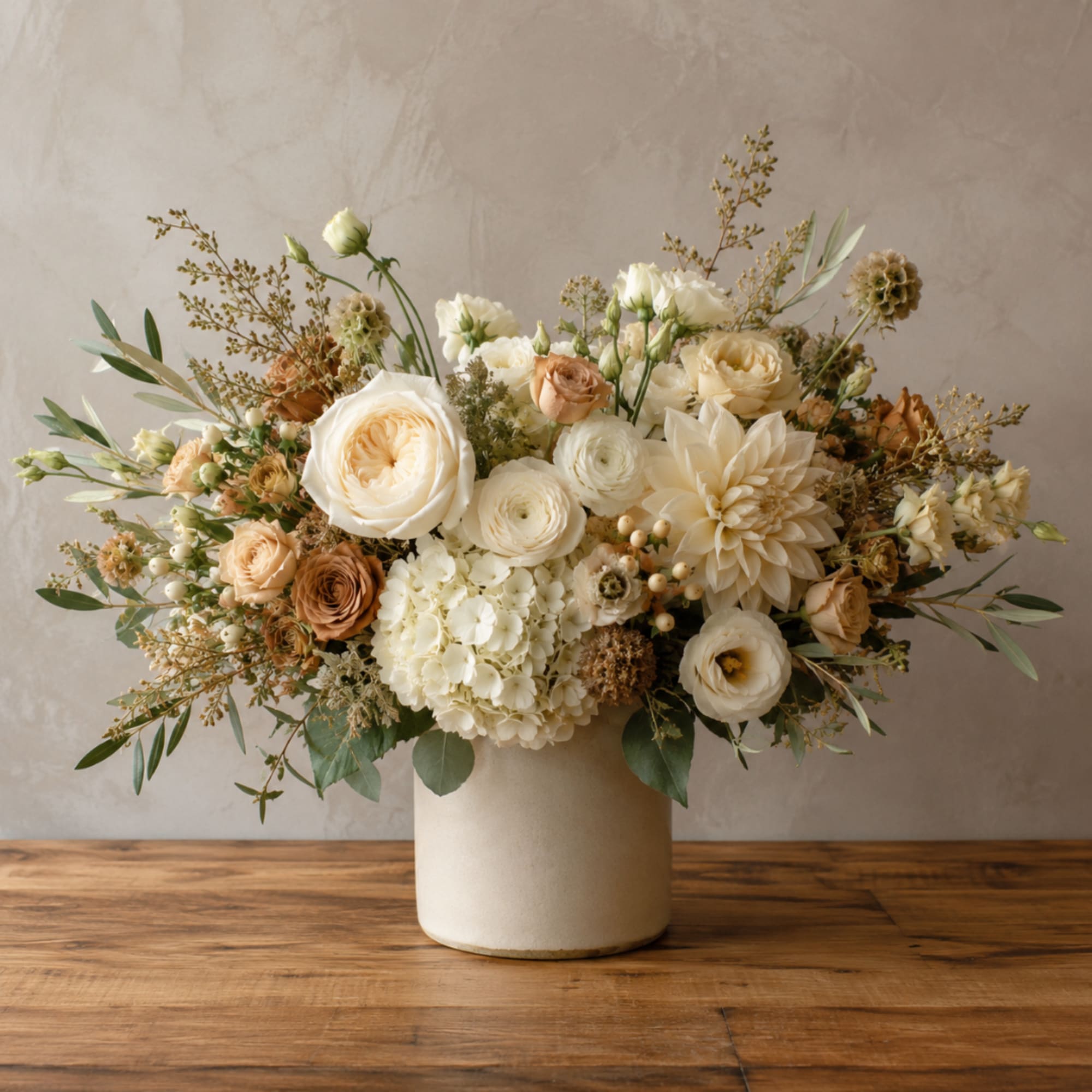 Cream and peach floral arrangement in a white vase