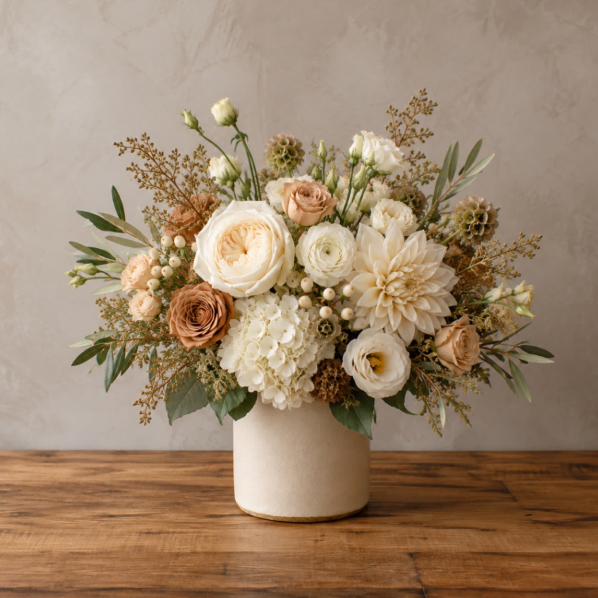 Cream and peach floral arrangement in a white vase