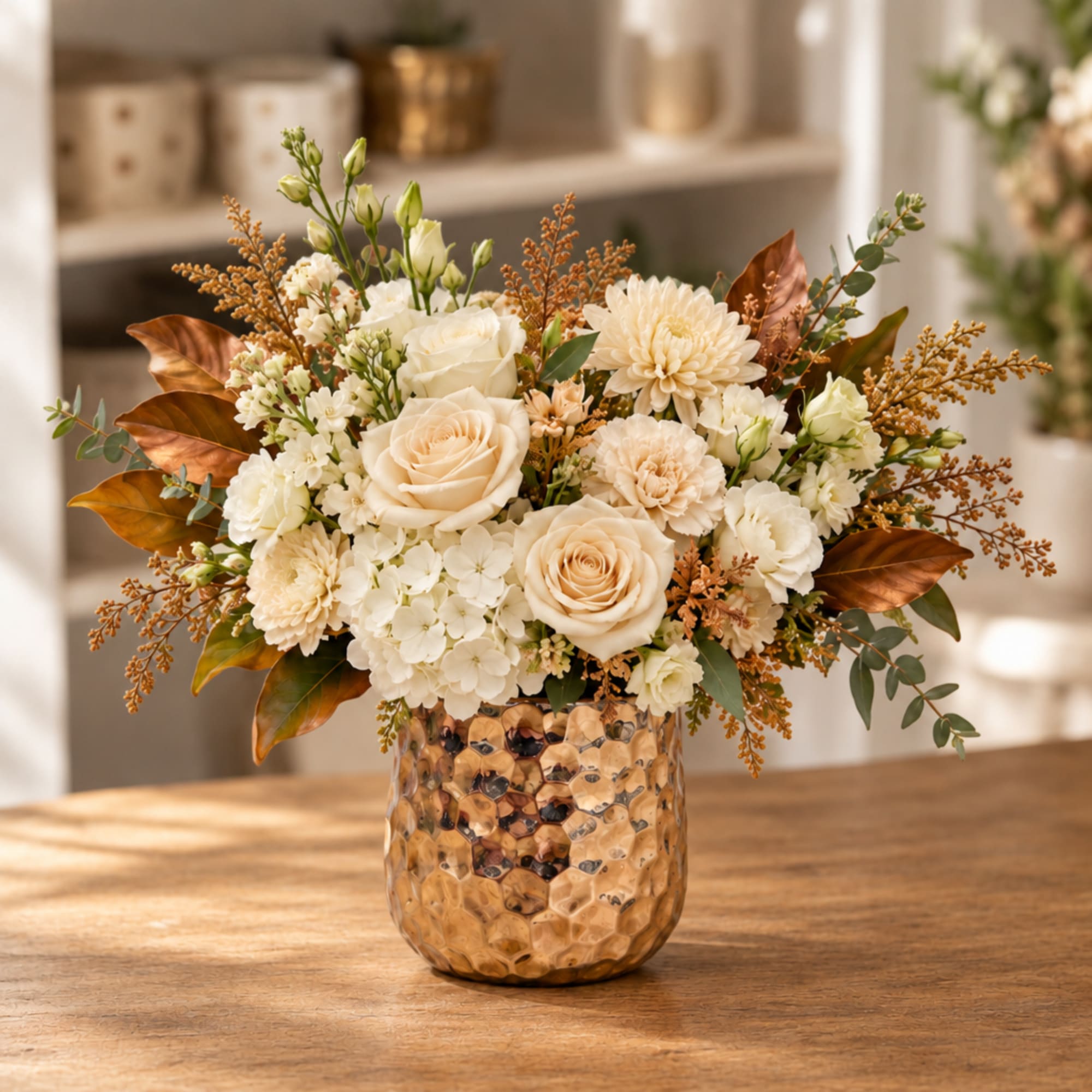 Cream floral arrangement in a textured gold vase