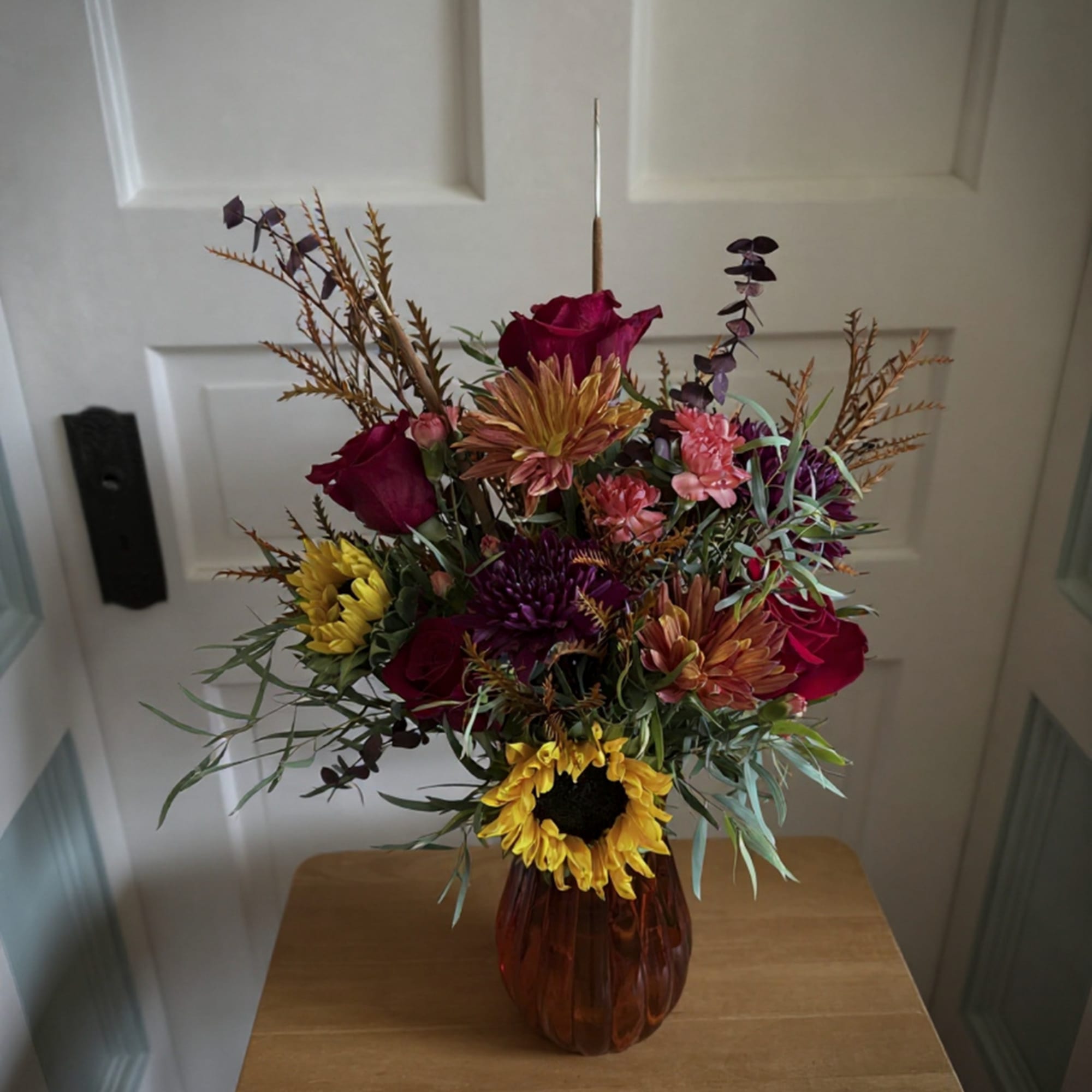 Mixed bouquet with roses and chrysanthemums in an amber vase