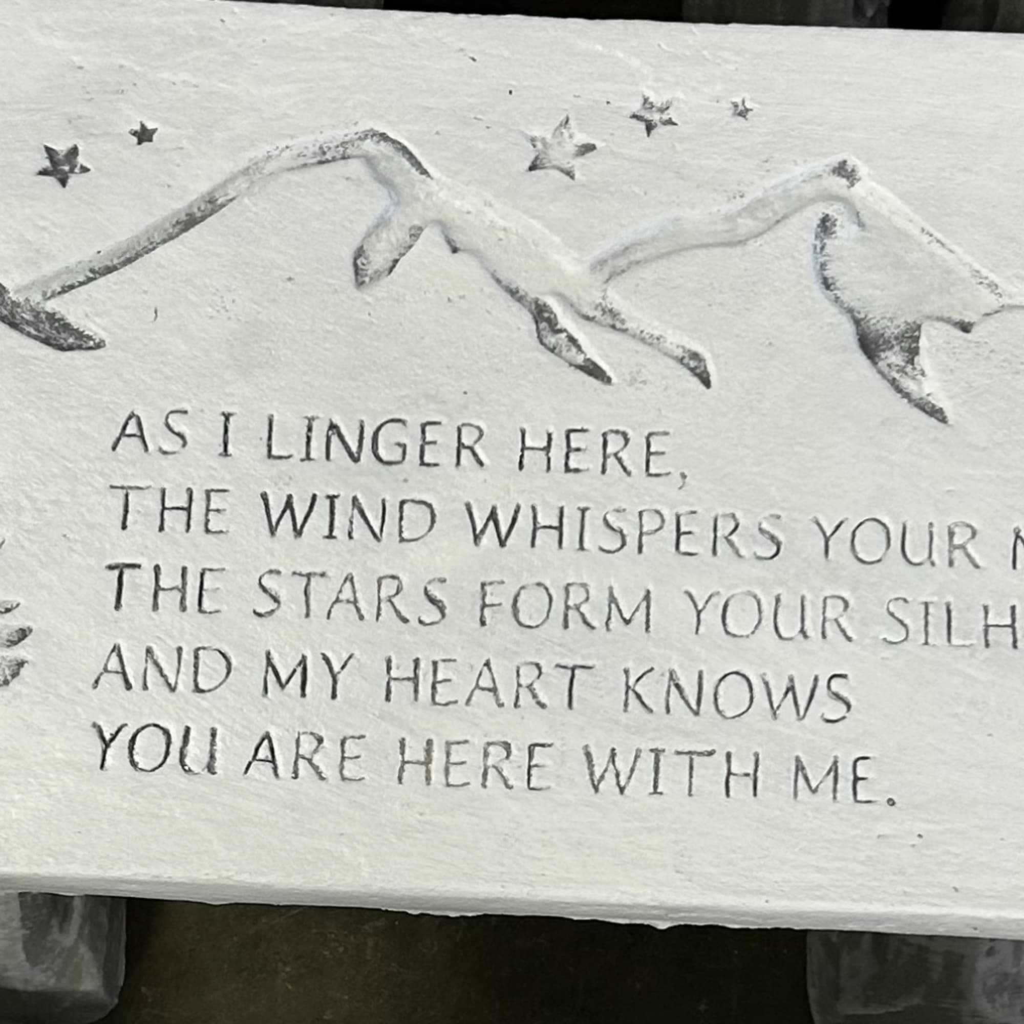 Stone plaque with a mountain relief and engraved memorial text