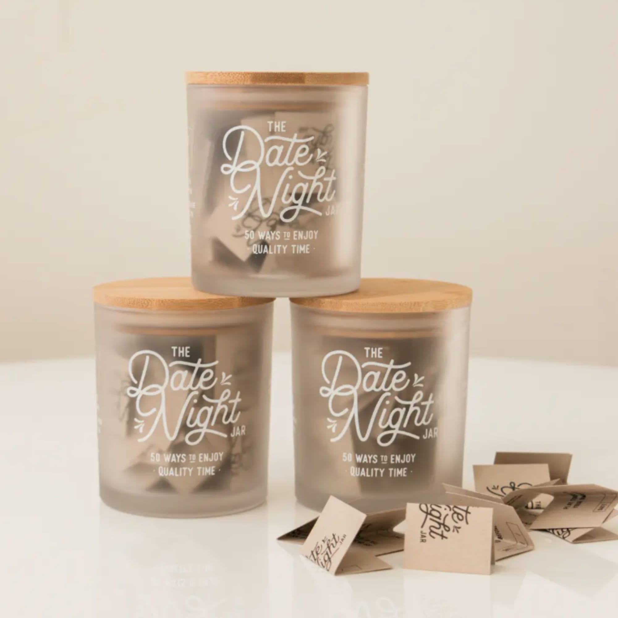 Three frosted jars with wooden lids labeled Date Night Jar