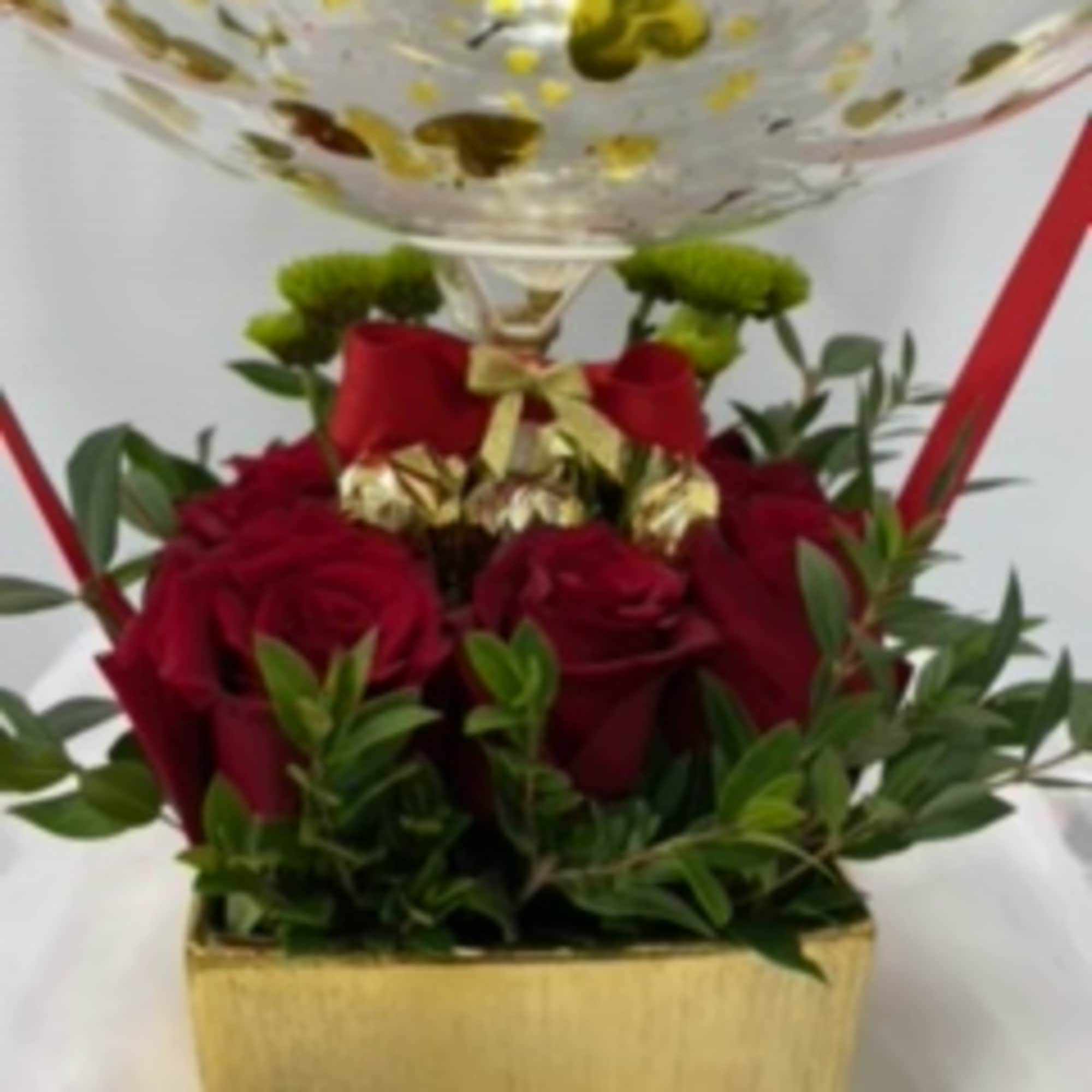 Red roses in a gold gift box with a clear balloon above
