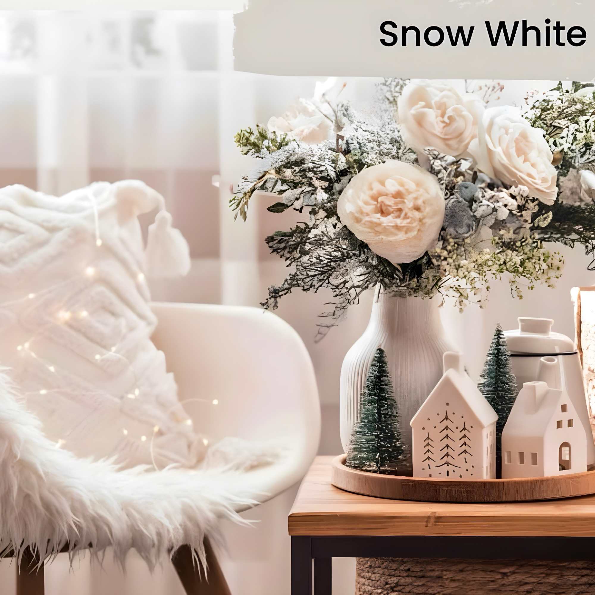 White rose arrangement in a vase with small house decorations