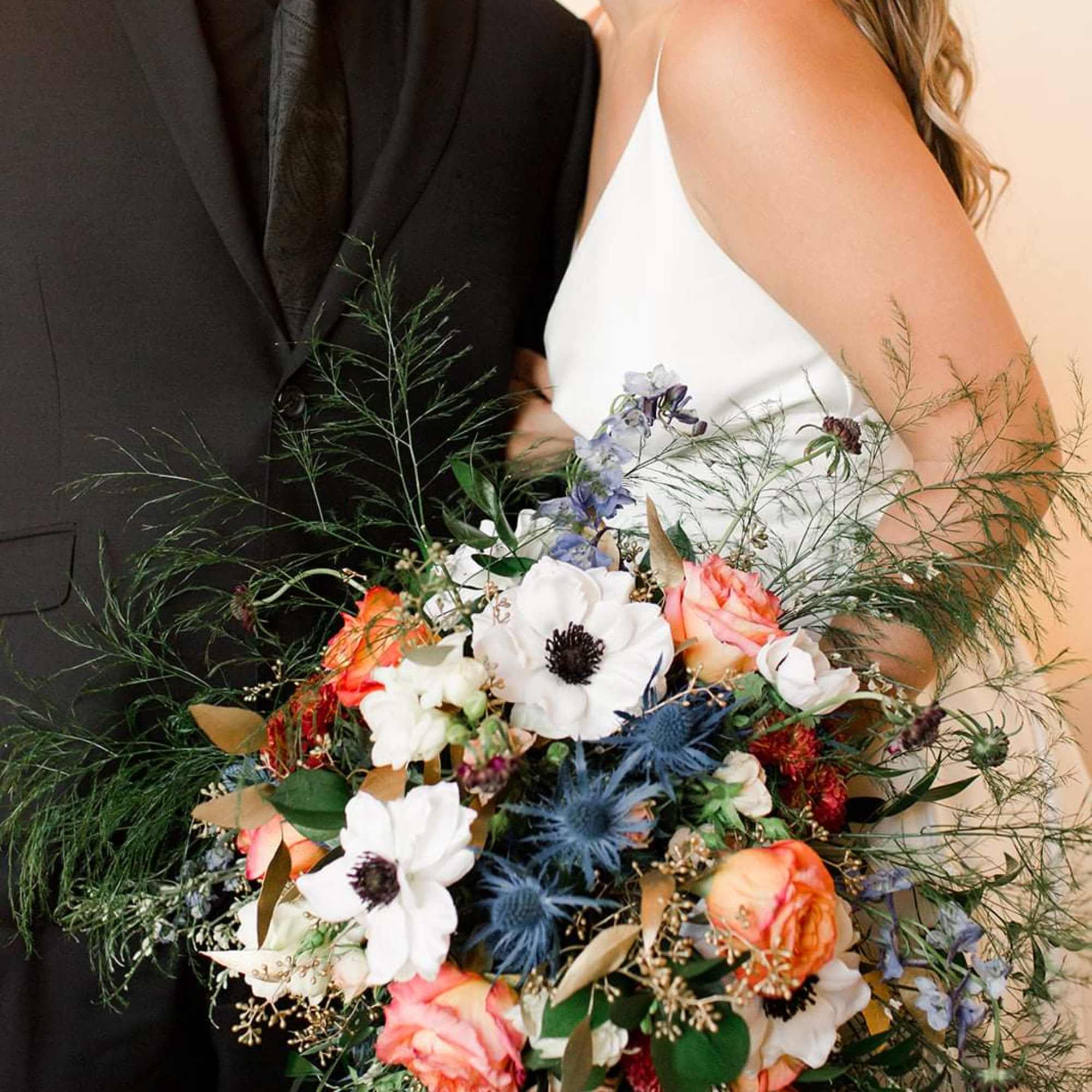 Bride and groom holding a colorful wedding bouquet