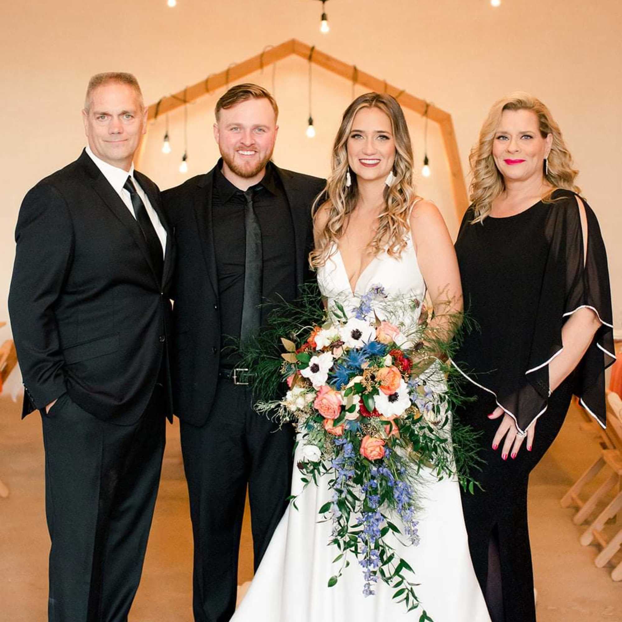 Bride holding a colorful cascading bouquet with wedding party members