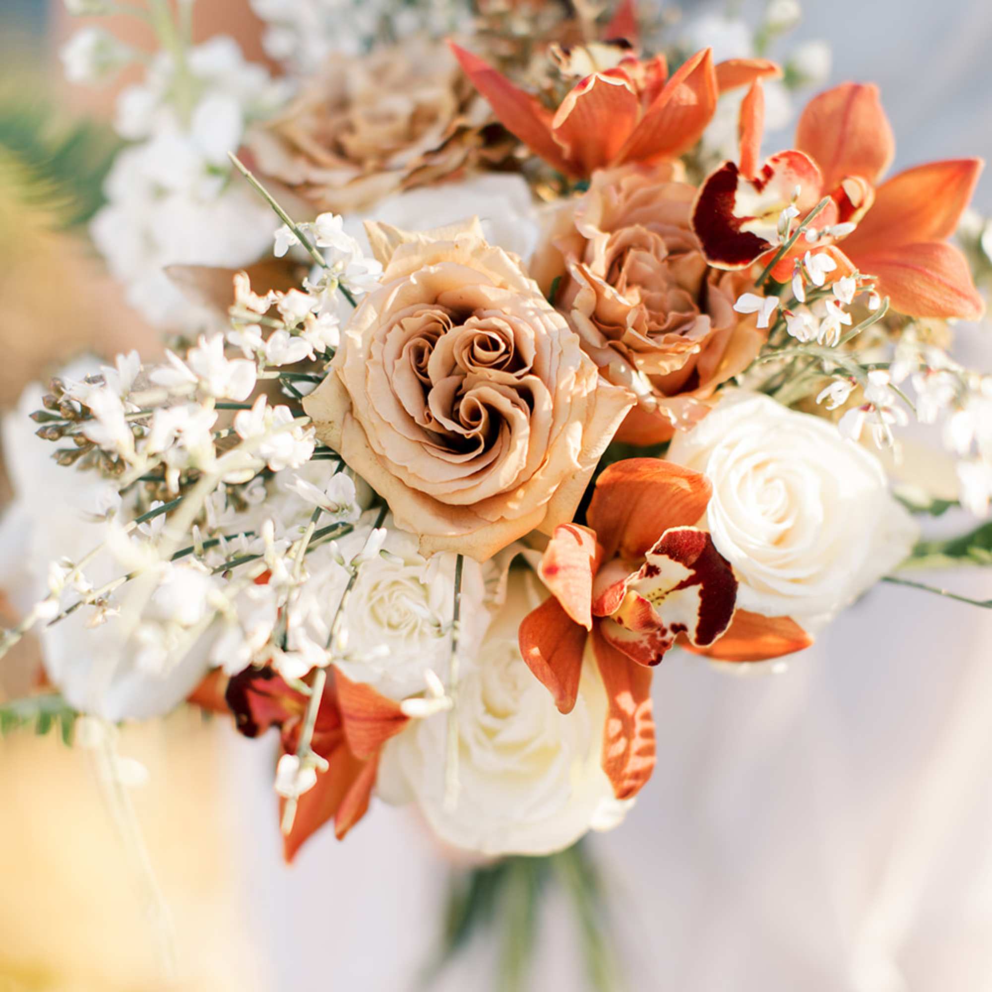 Bouquet of peach and white roses with orange orchids