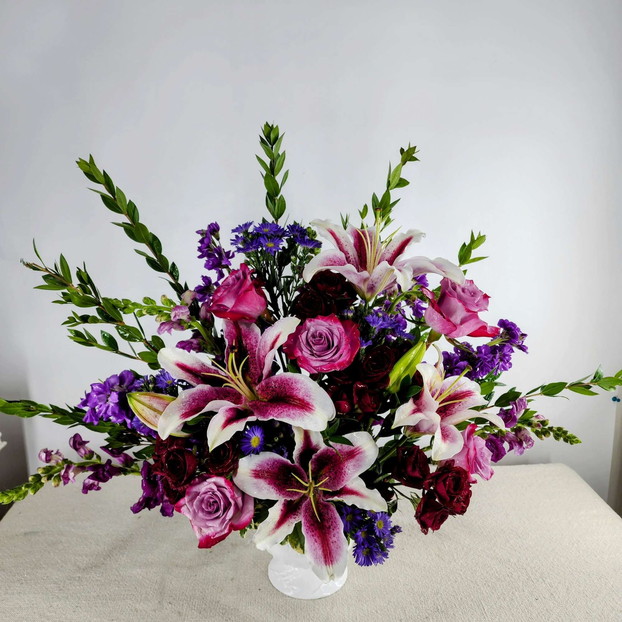 Bouquet of pink and white lilies with roses in a white vase