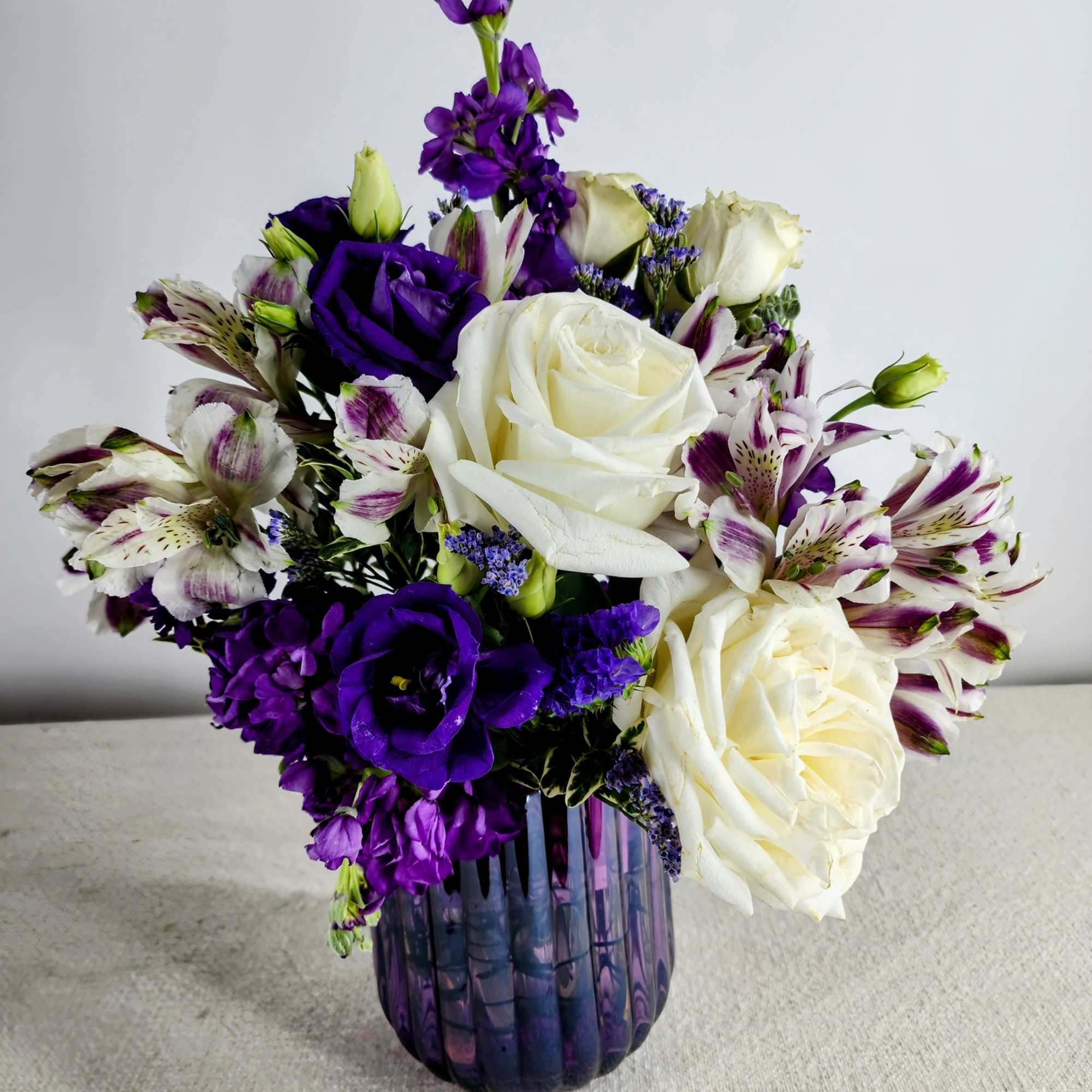 Purple and white bouquet in a glass vase