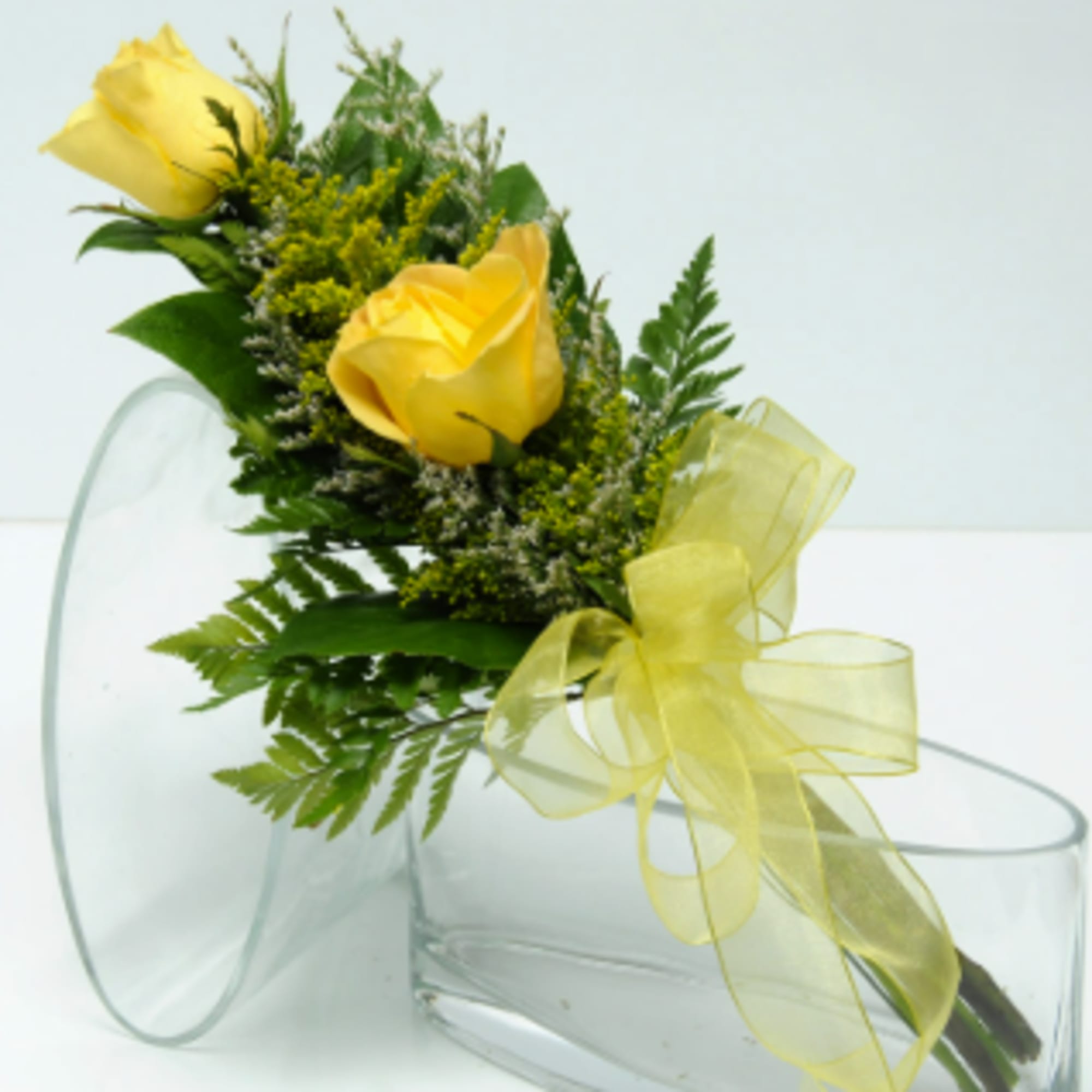 Yellow rose bouquet with a sheer ribbon in a clear glass vase