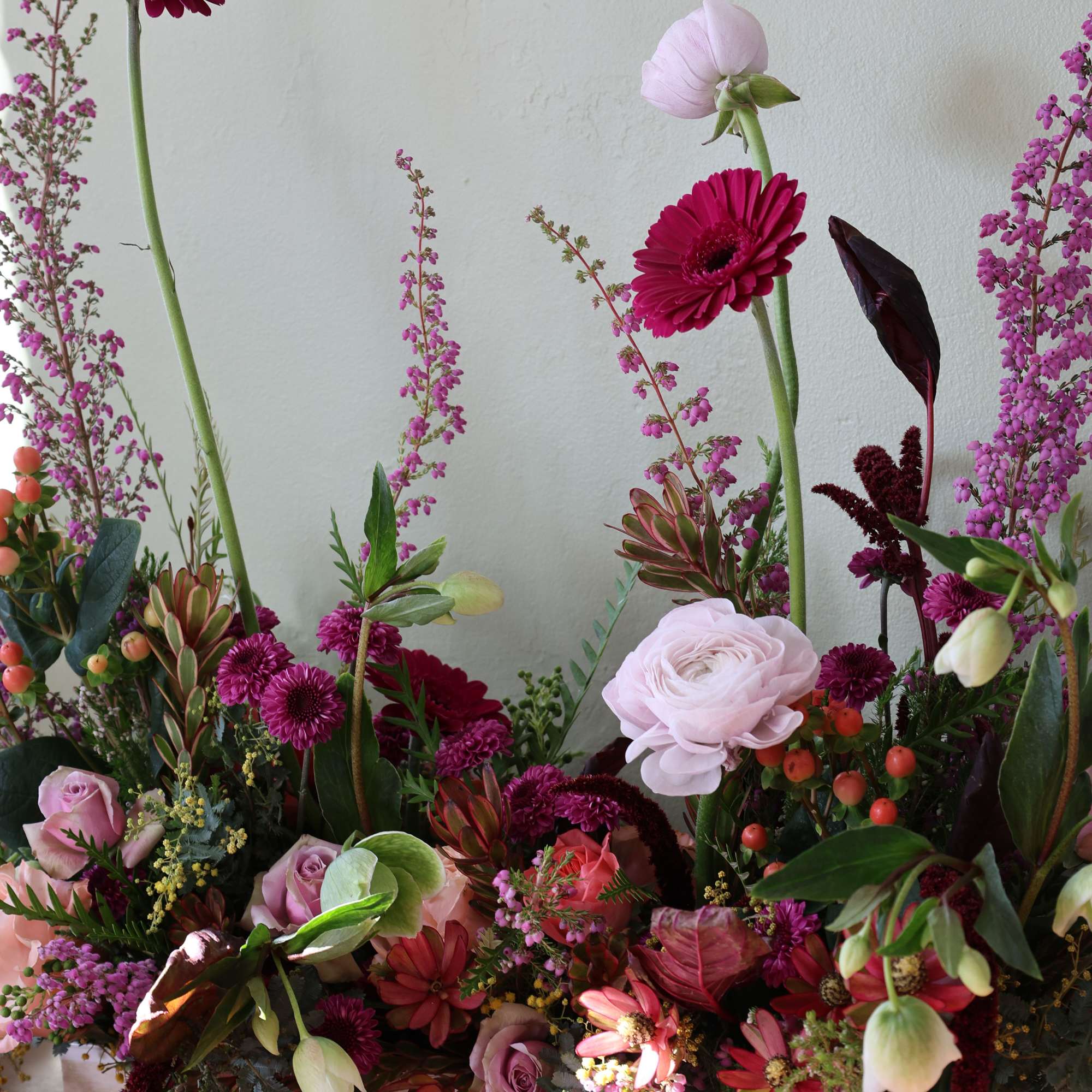 Mixed pink and burgundy floral arrangement in a rectangular wooden box