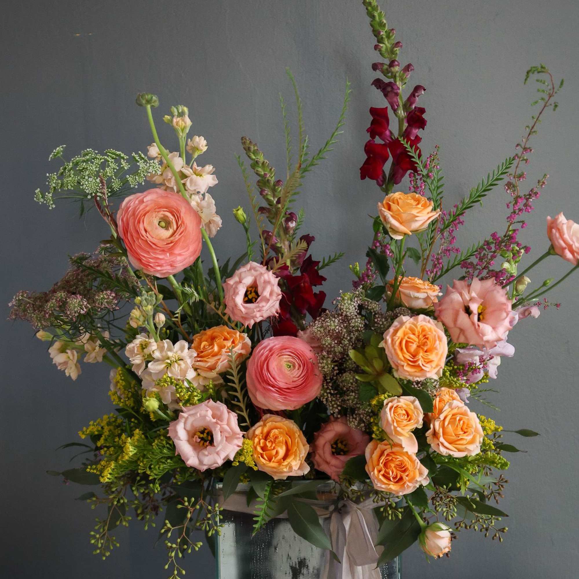 a whimsical and garden one sided arrangement in a beautiful keepsake mirror
