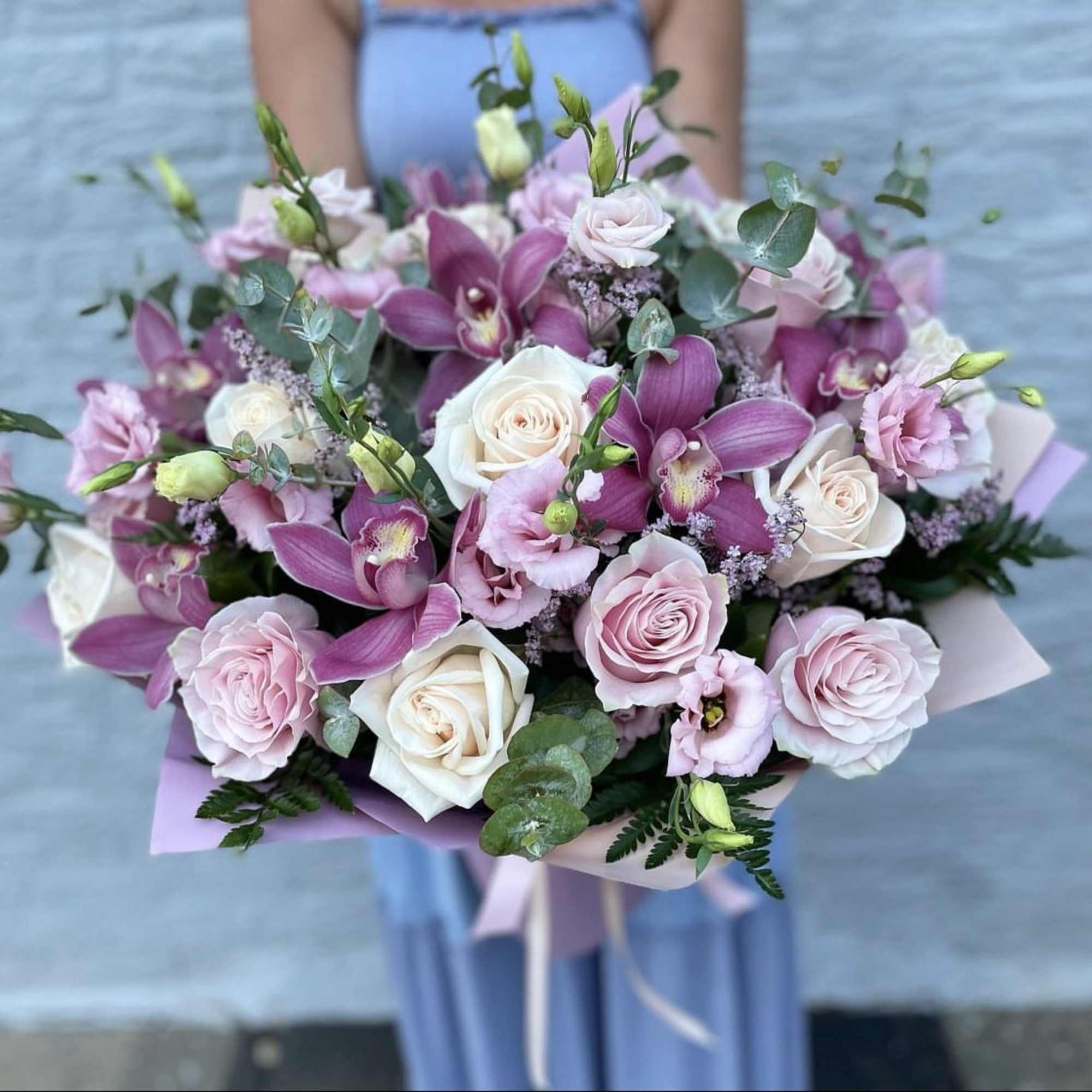 Bouquet of pink and white roses with purple orchids