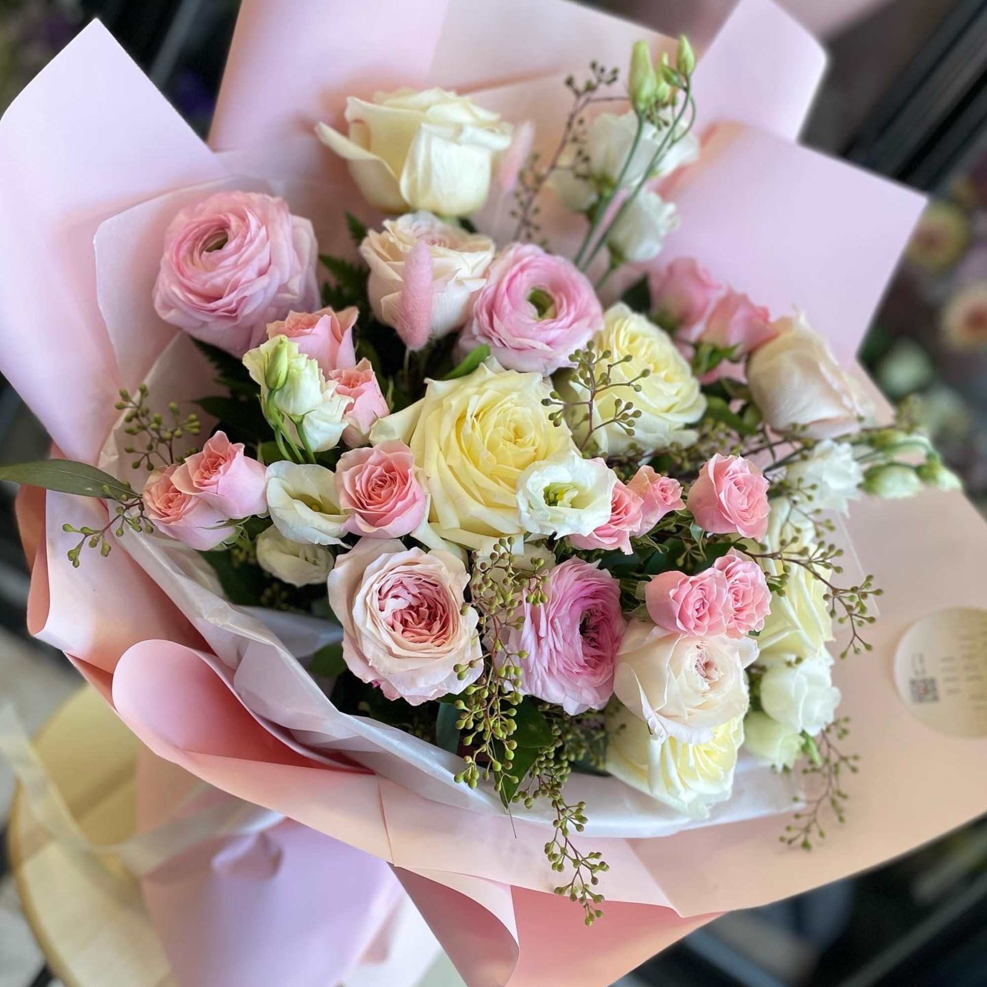 Pink and cream rose bouquet wrapped in pastel paper