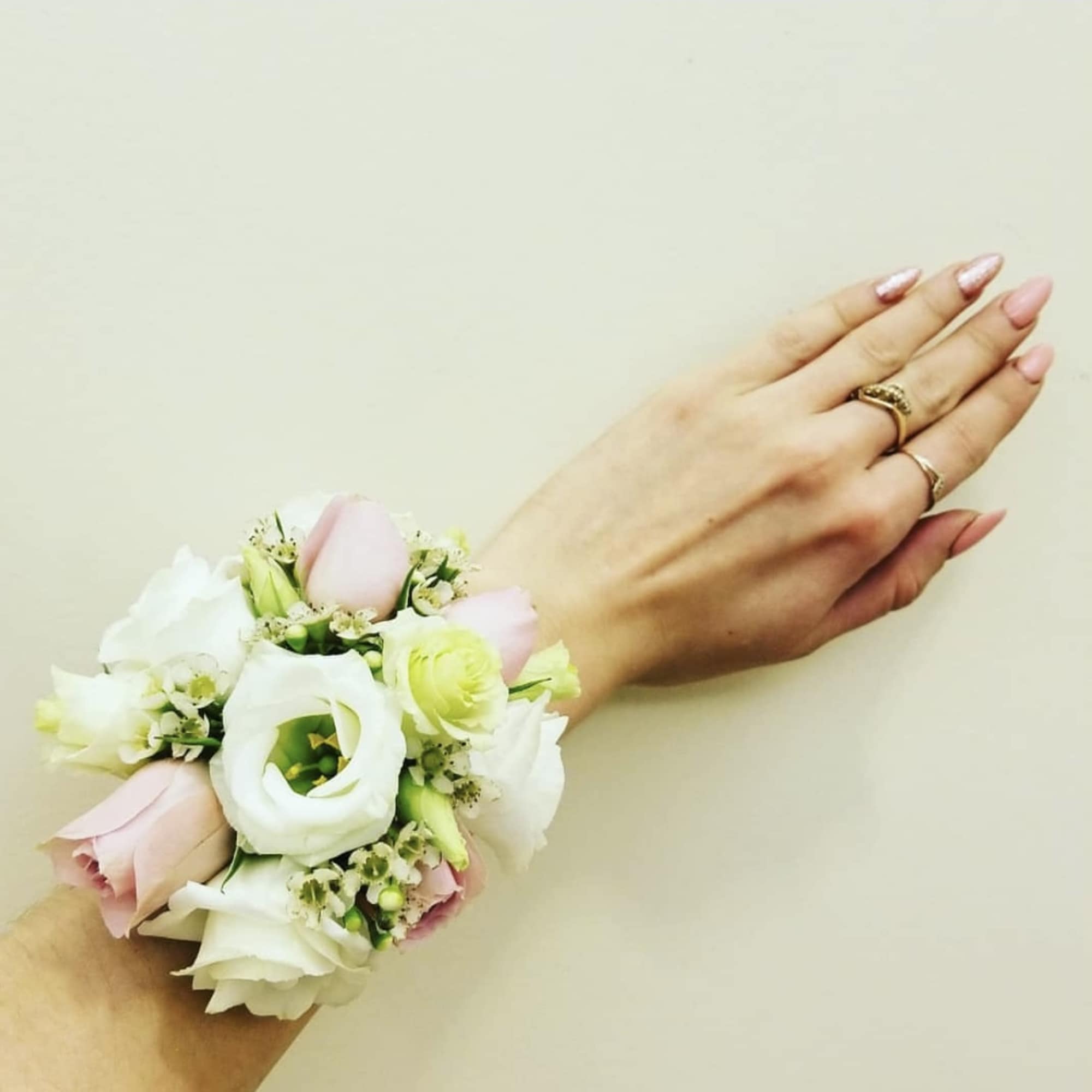 Pastel floral wrist corsage on a person's wrist