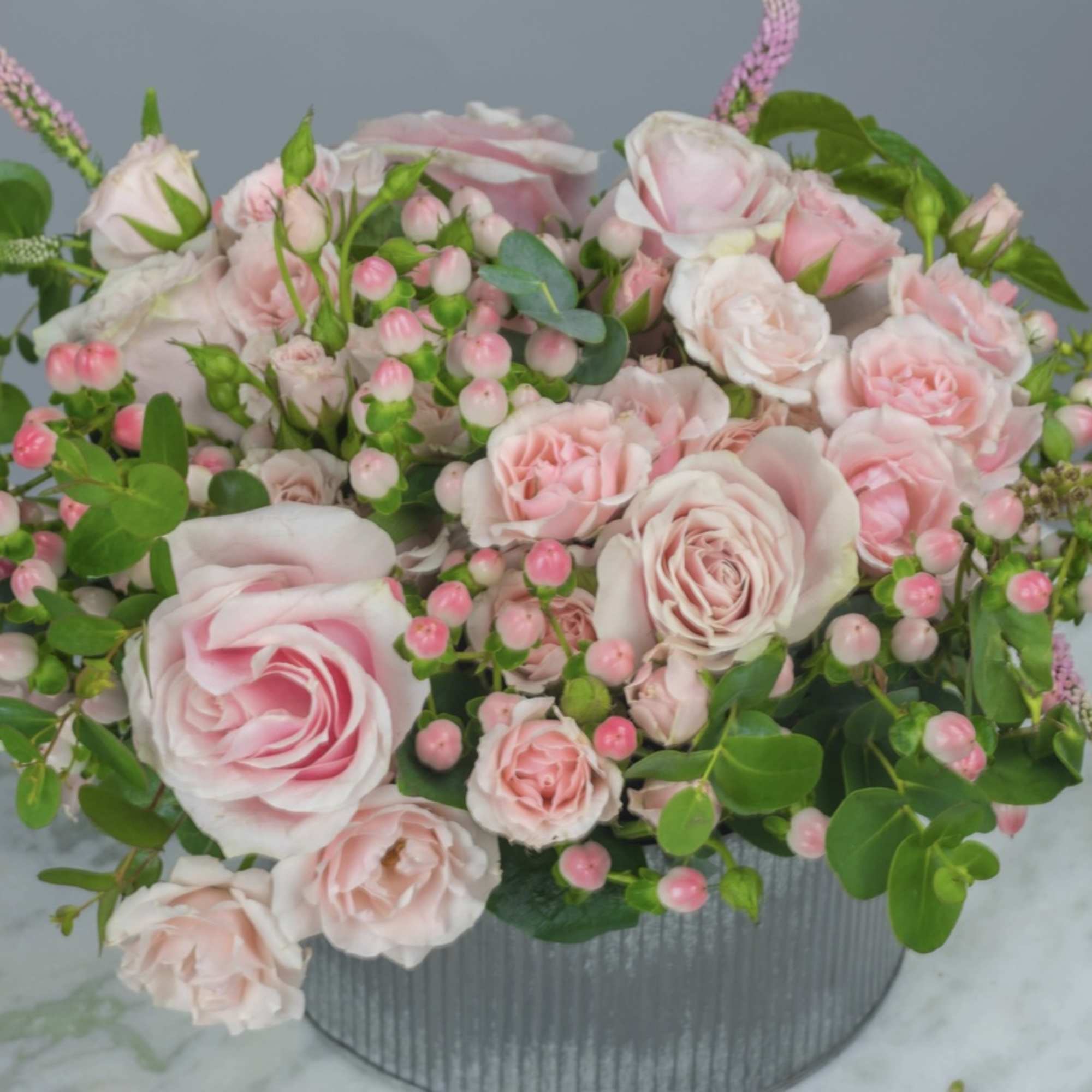 Pink rose bouquet in a ribbed gray container