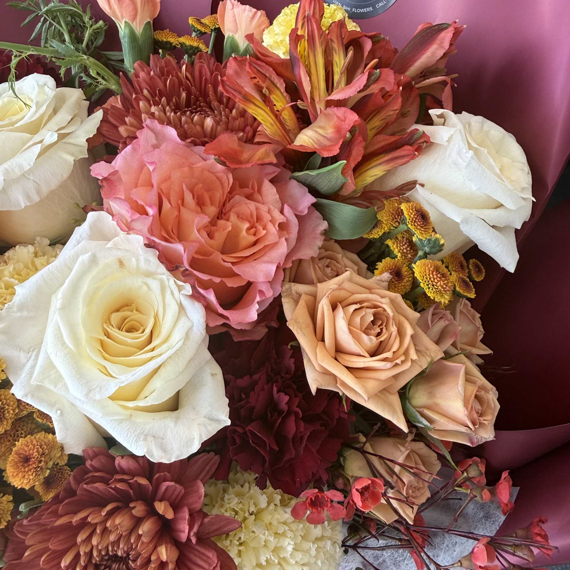 Mixed bouquet with roses, chrysanthemums, and carnations in pink wrapping