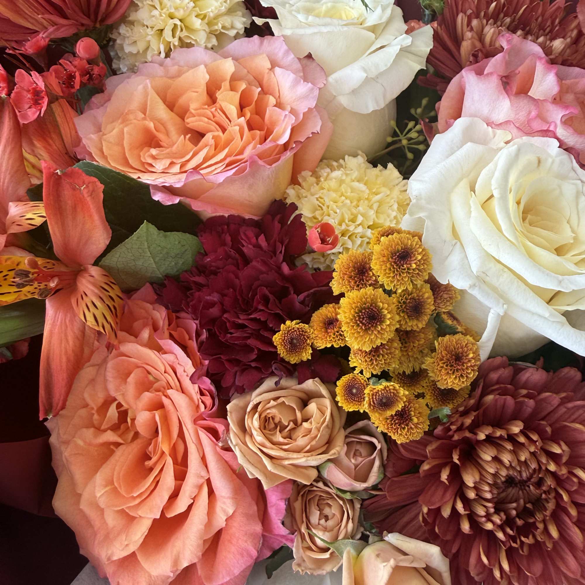 Mixed bouquet of roses, carnations, and chrysanthemums in pink, white, and peach