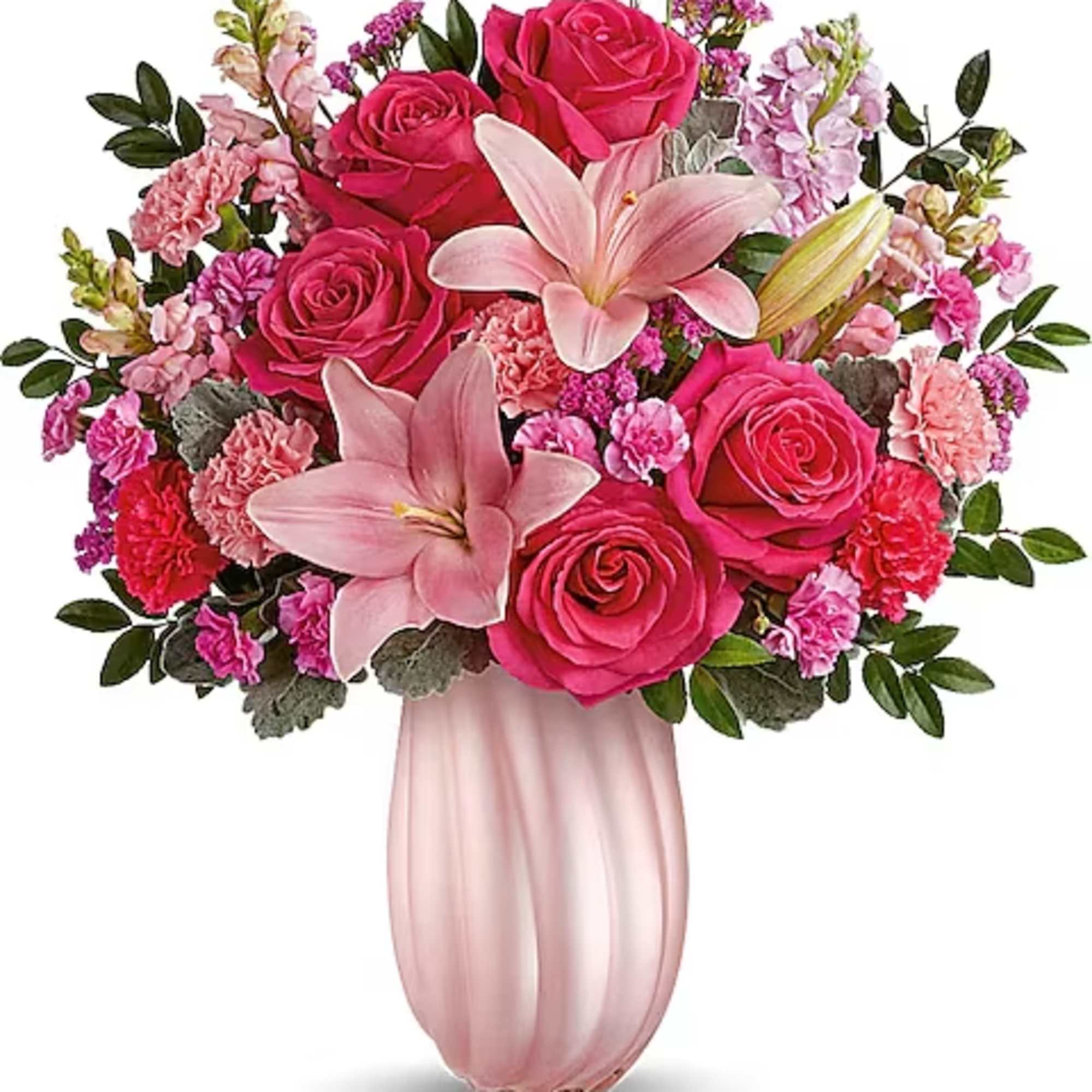 Pink roses and lilies arranged in a blush vase