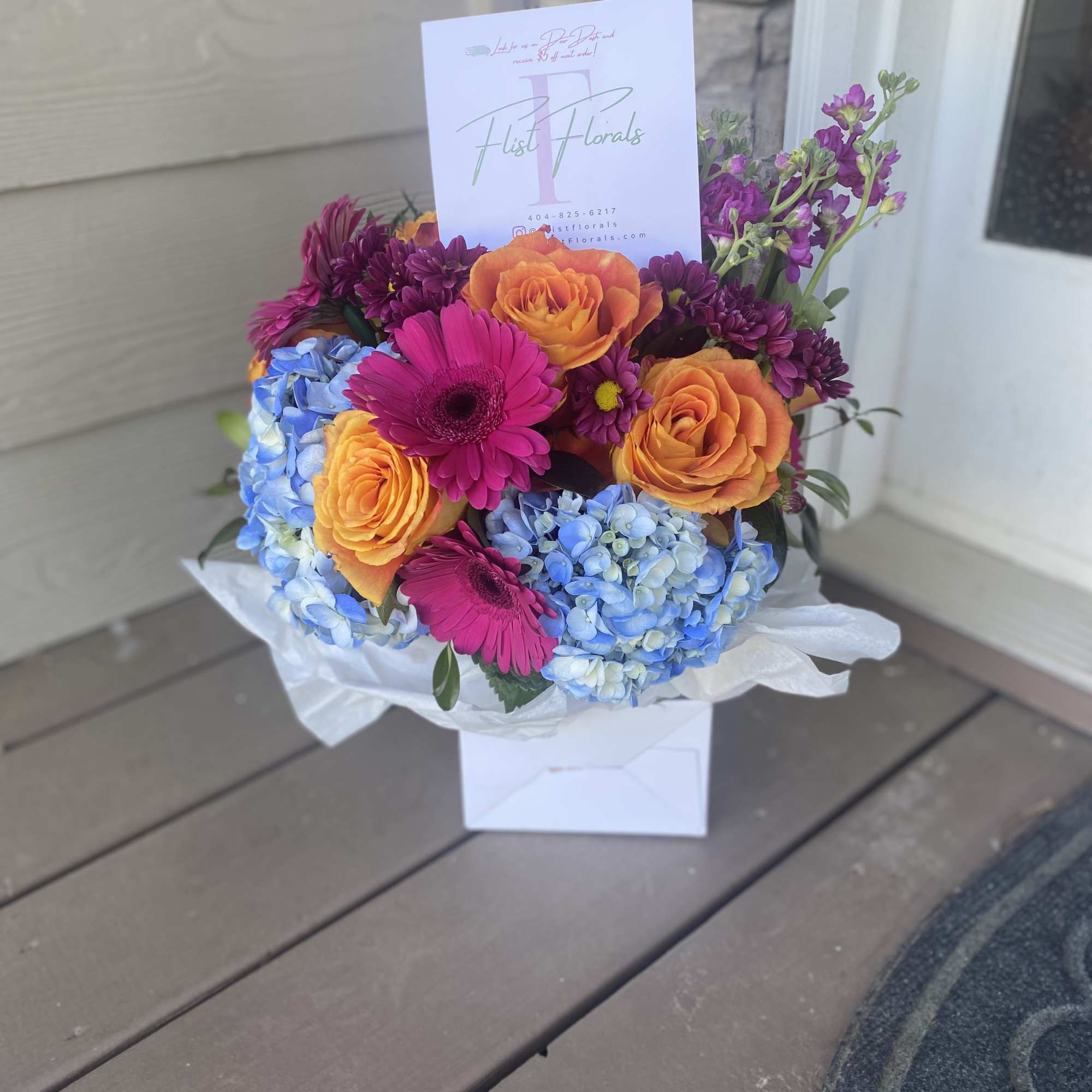 With the mixture of hot pink gerb daisies, orange roses and blue, photo 3 of 3