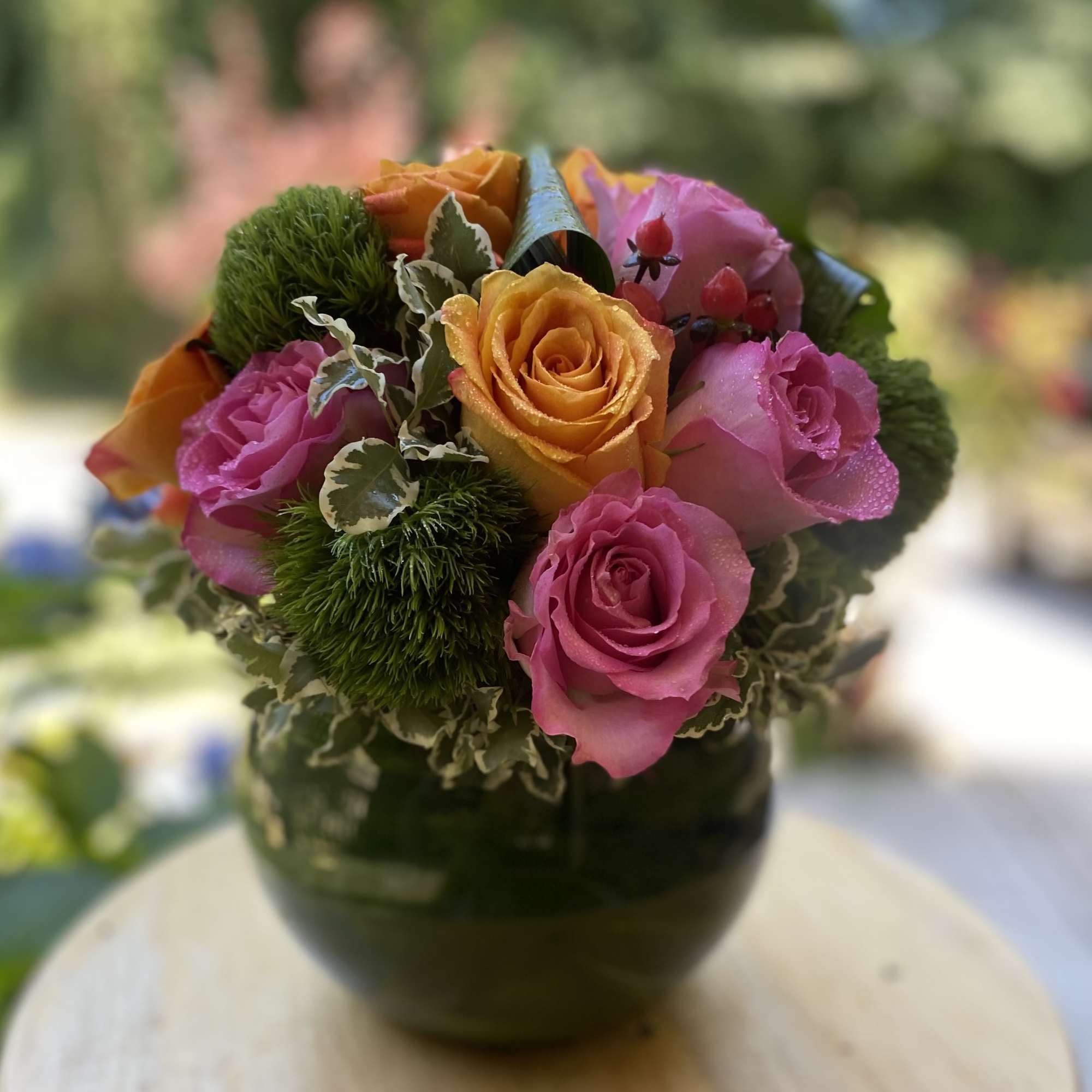 Brighten any space with this vibrant floral arrangement featuring bold orange and