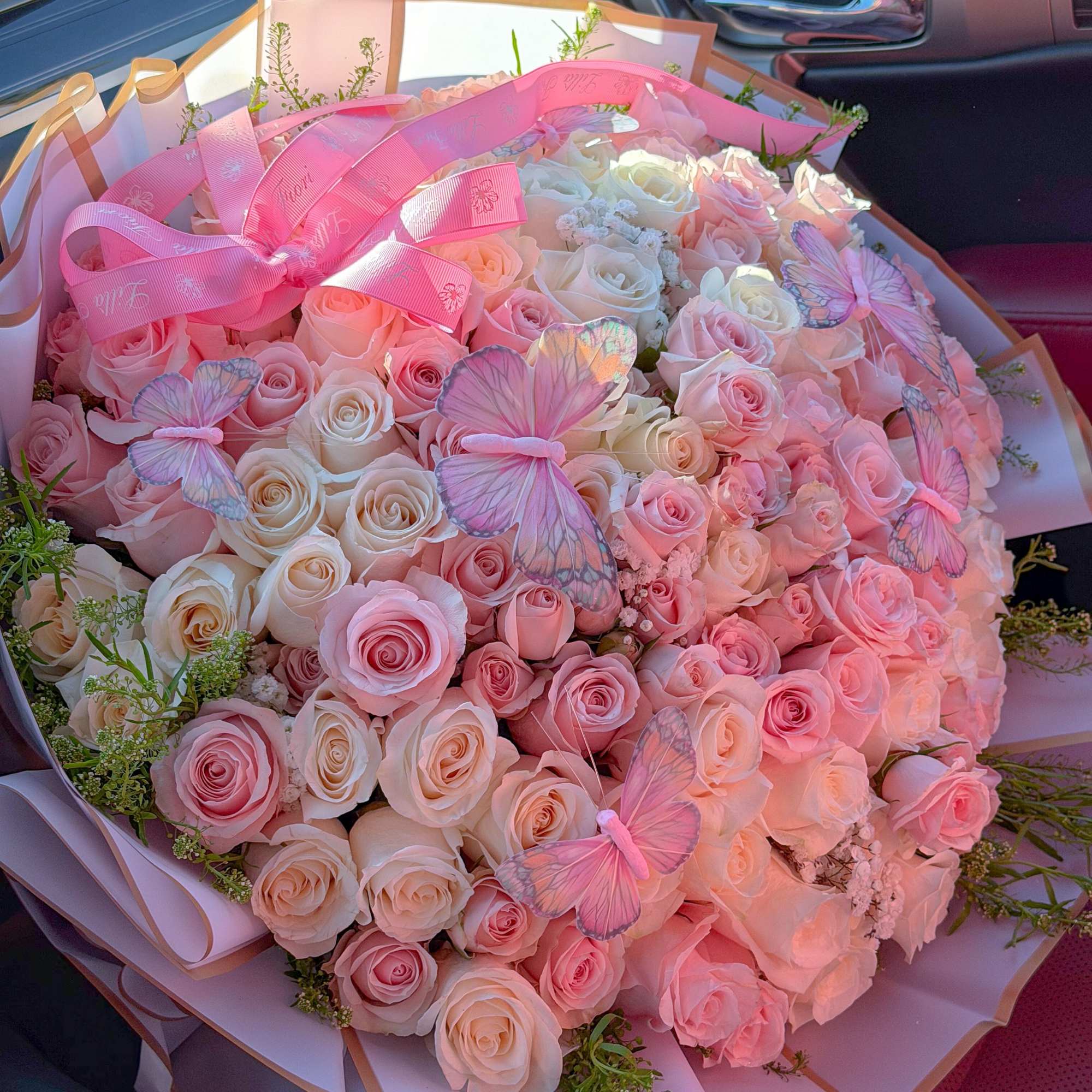 Large bouquet of pink and white roses with butterfly decorations