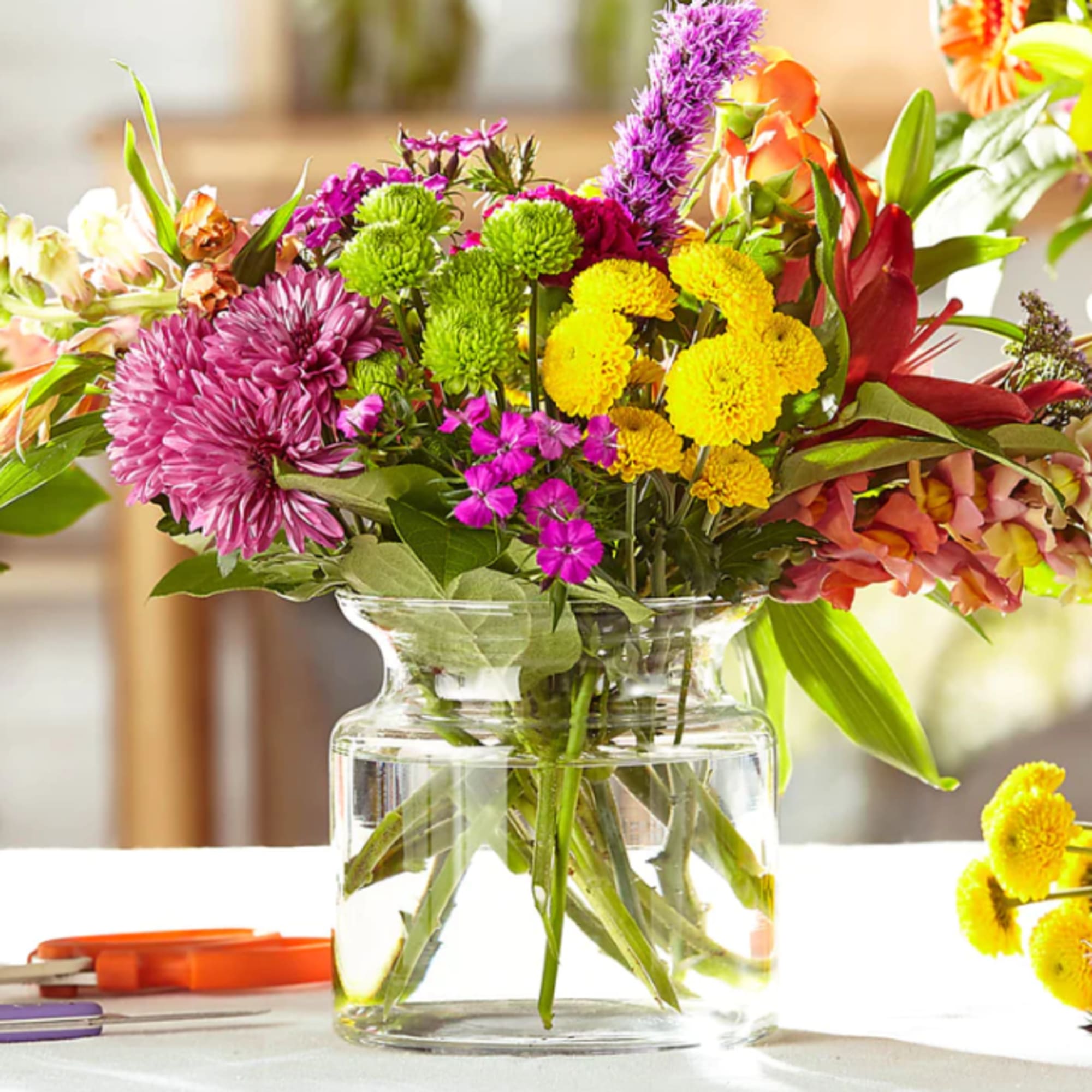 Mixed bouquet of colorful flowers in a clear glass vase