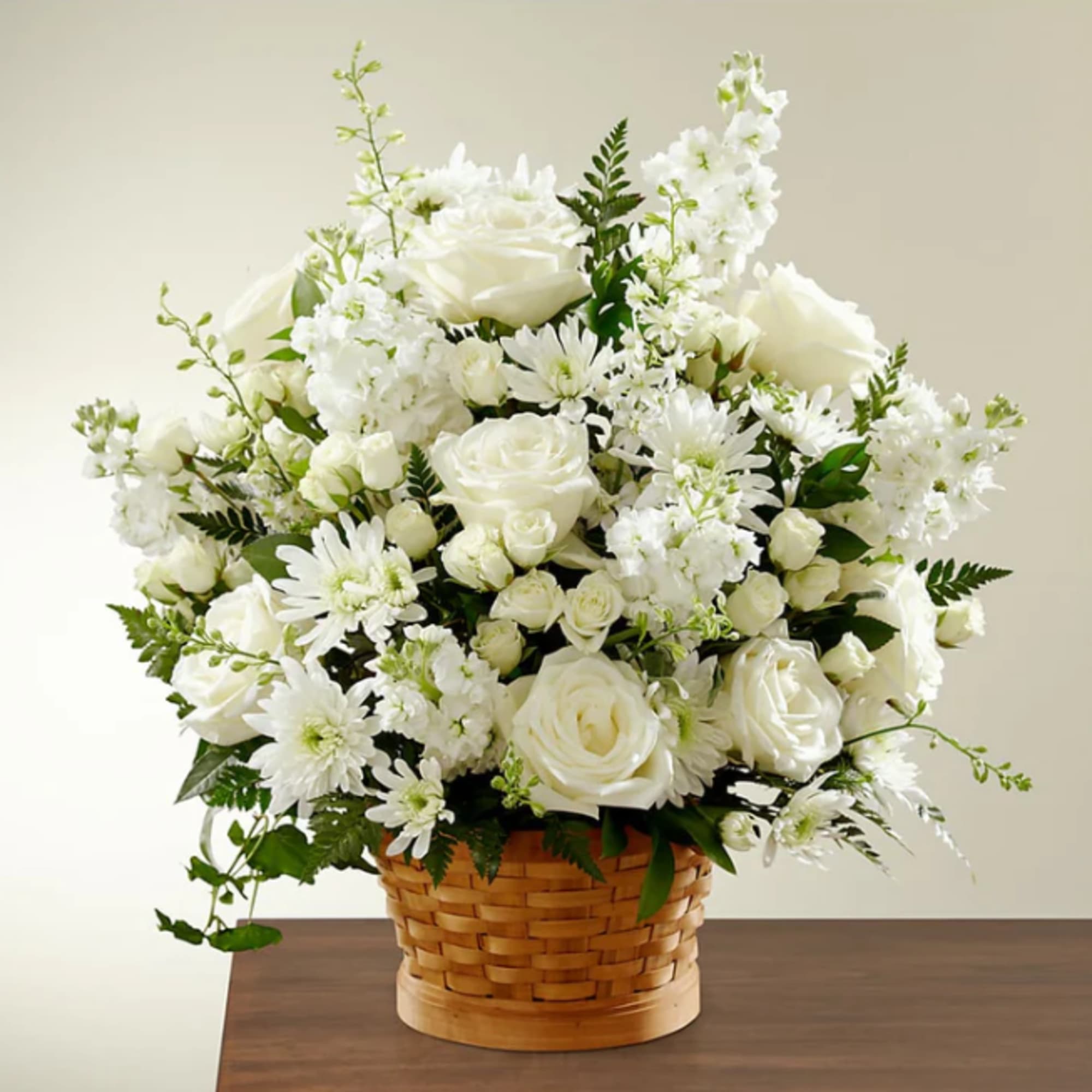 White roses and daisies arranged in a woven basket