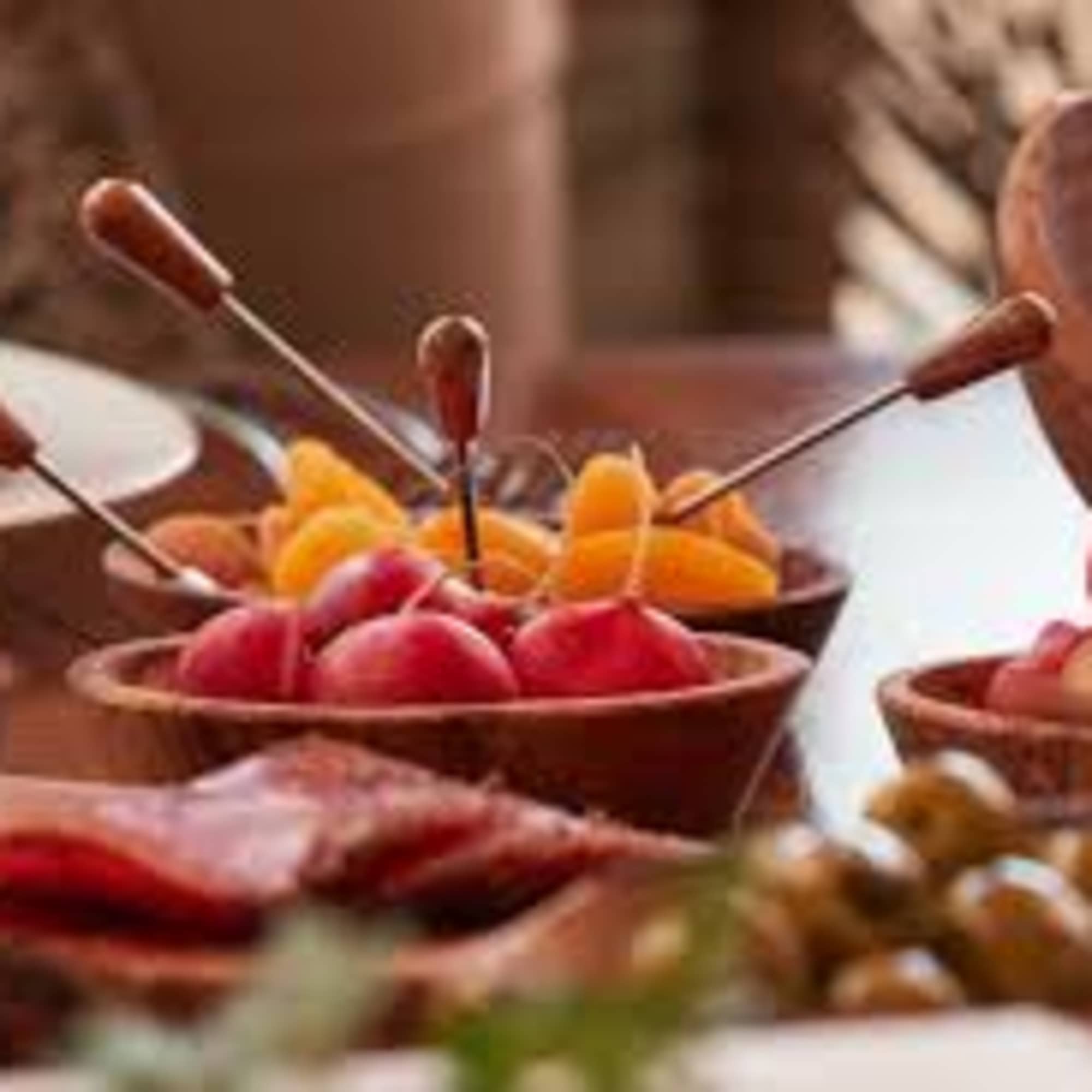 Bowls of assorted fruit with small serving picks on a table