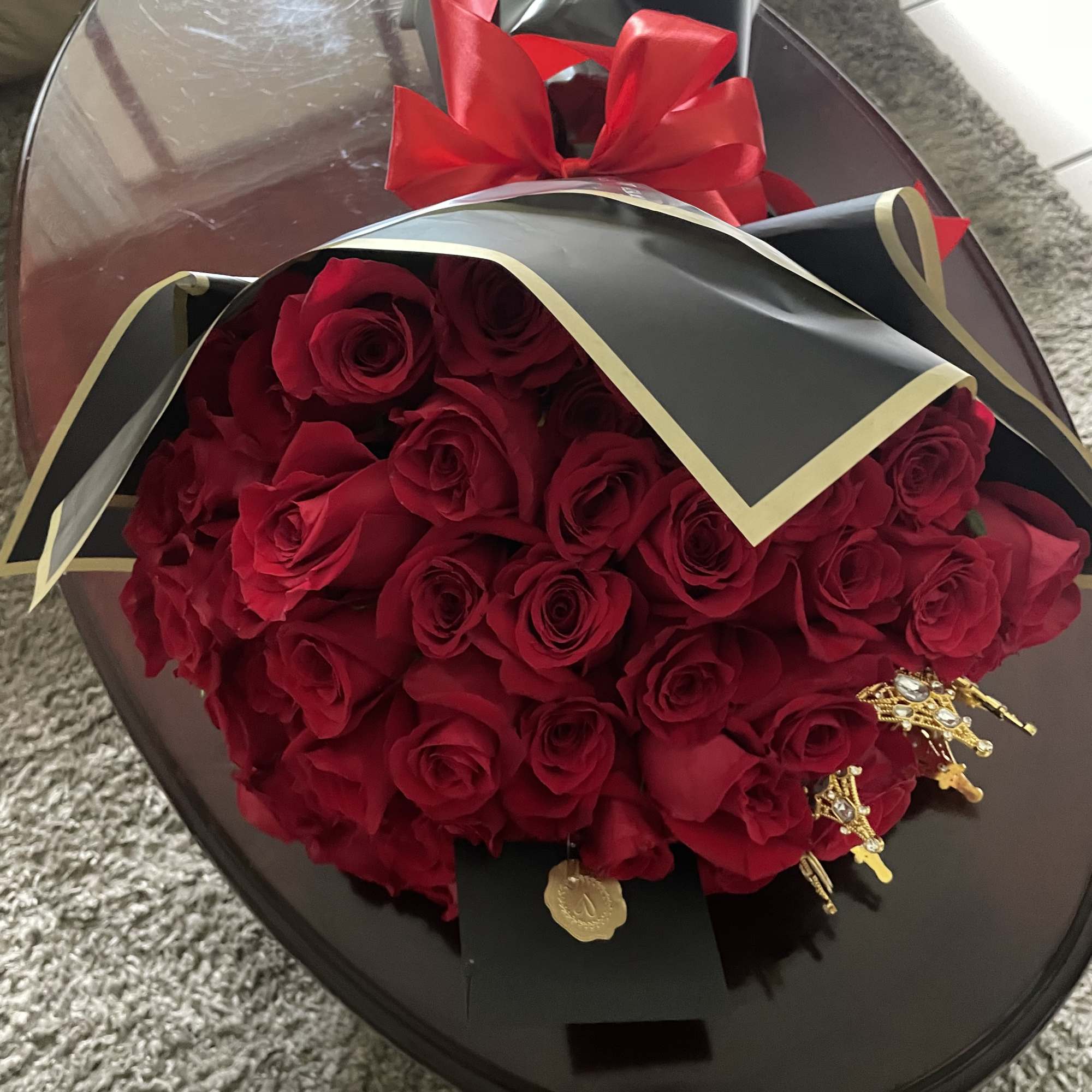 Bouquet of red roses wrapped in black paper with a red ribbon