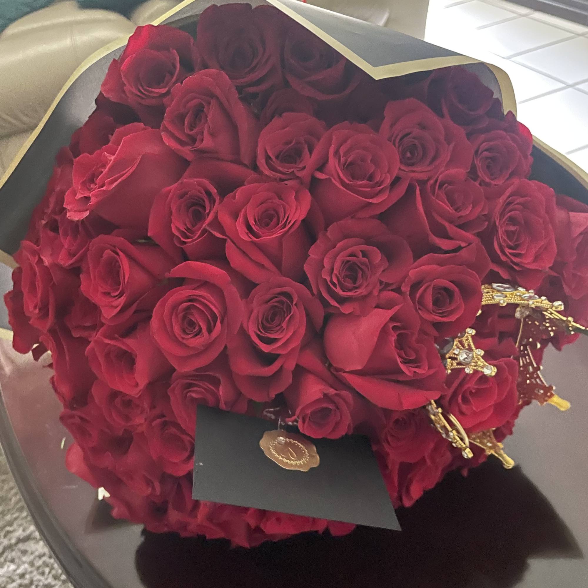 Bouquet of red roses wrapped in black paper with gold trim, photo 2 of 5