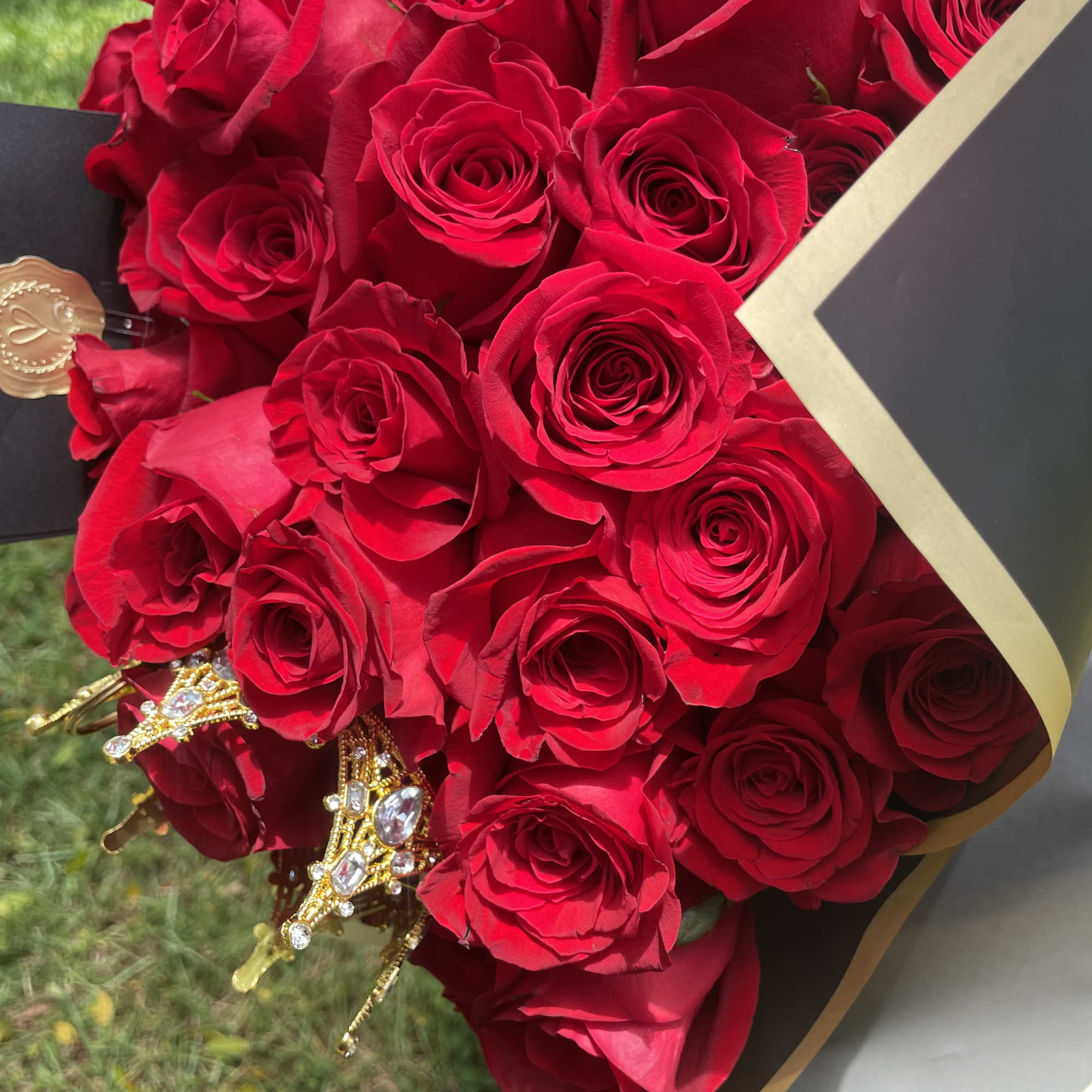 Bouquet of red roses wrapped in black paper with gold trim, photo 3 of 5