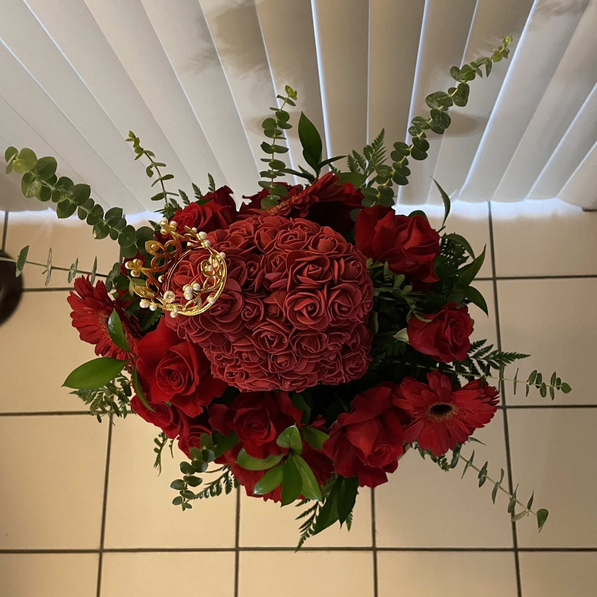 Red rose bouquet with a round rose center and trailing greenery