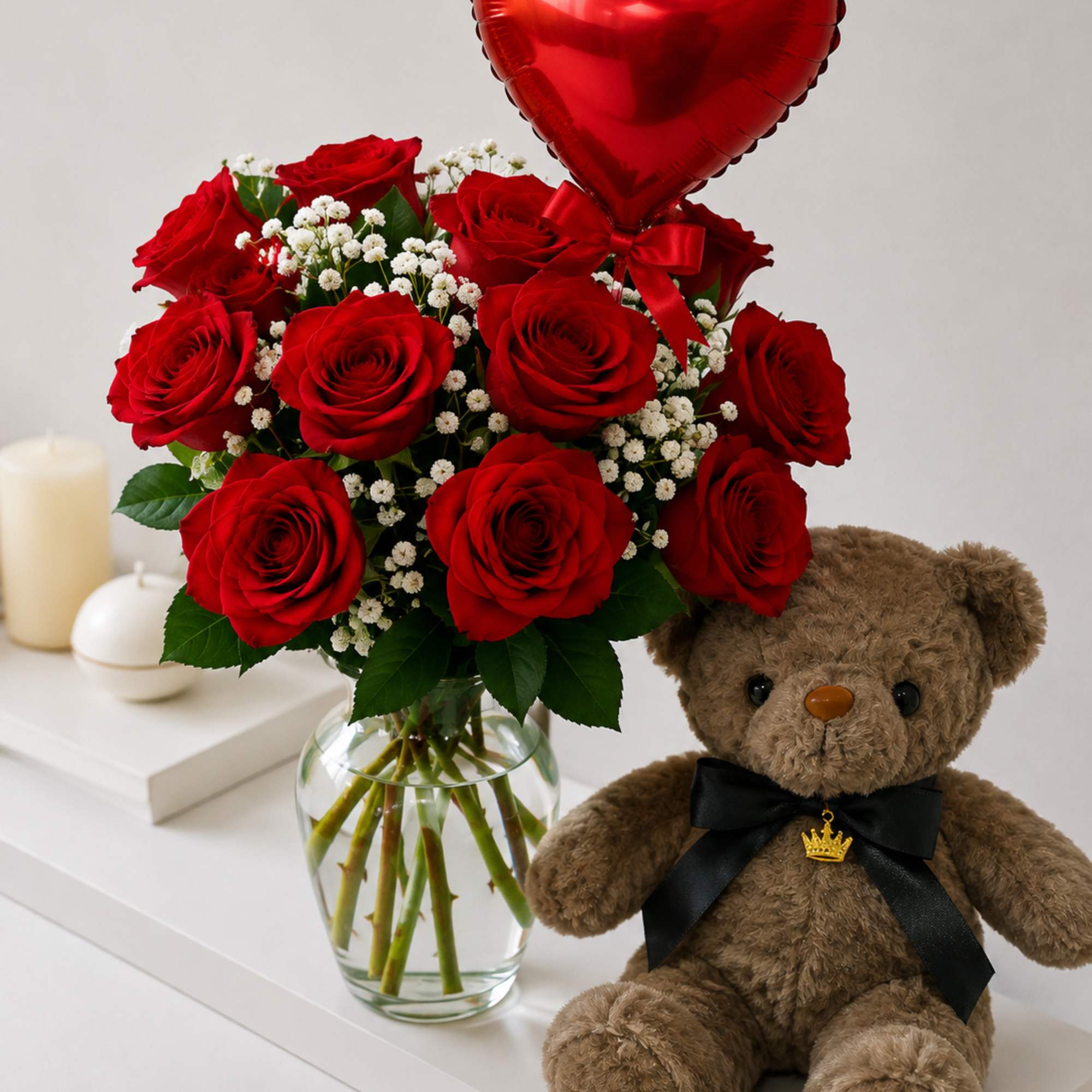 Red roses in a glass vase with a heart balloon and teddy bear