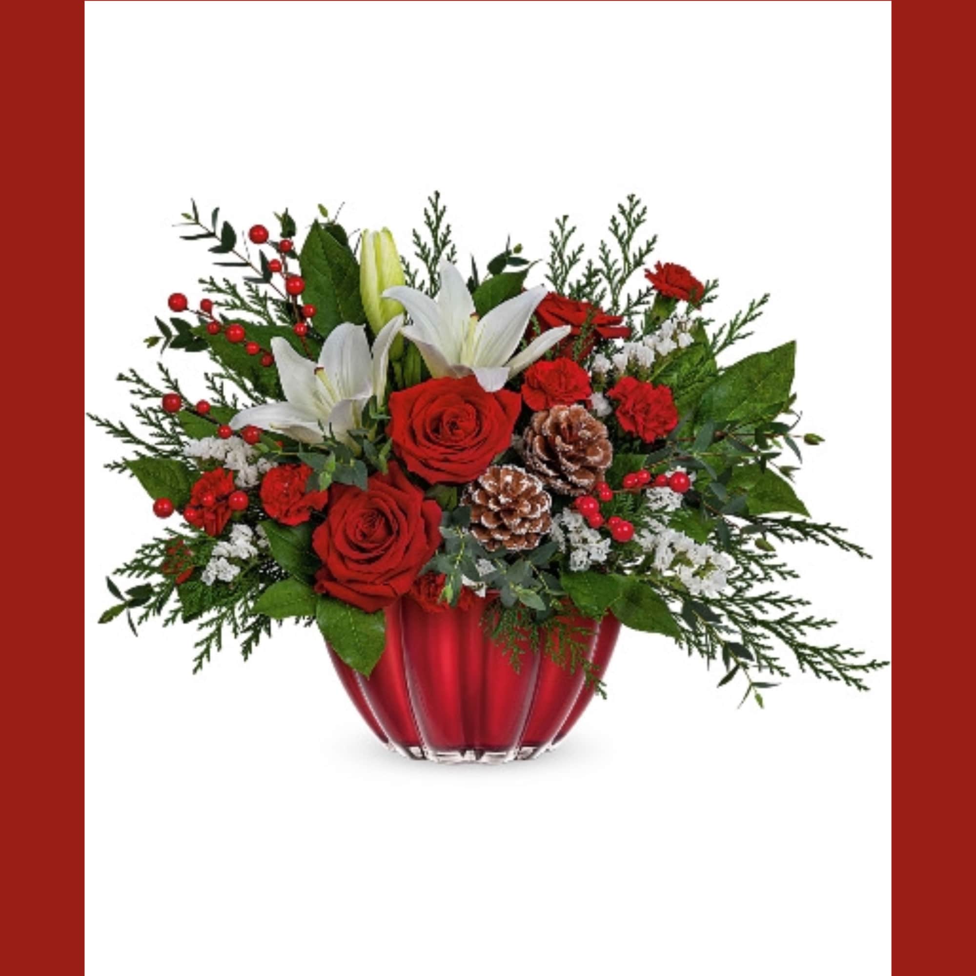Red roses and white lilies in a red vase with pinecones and berries